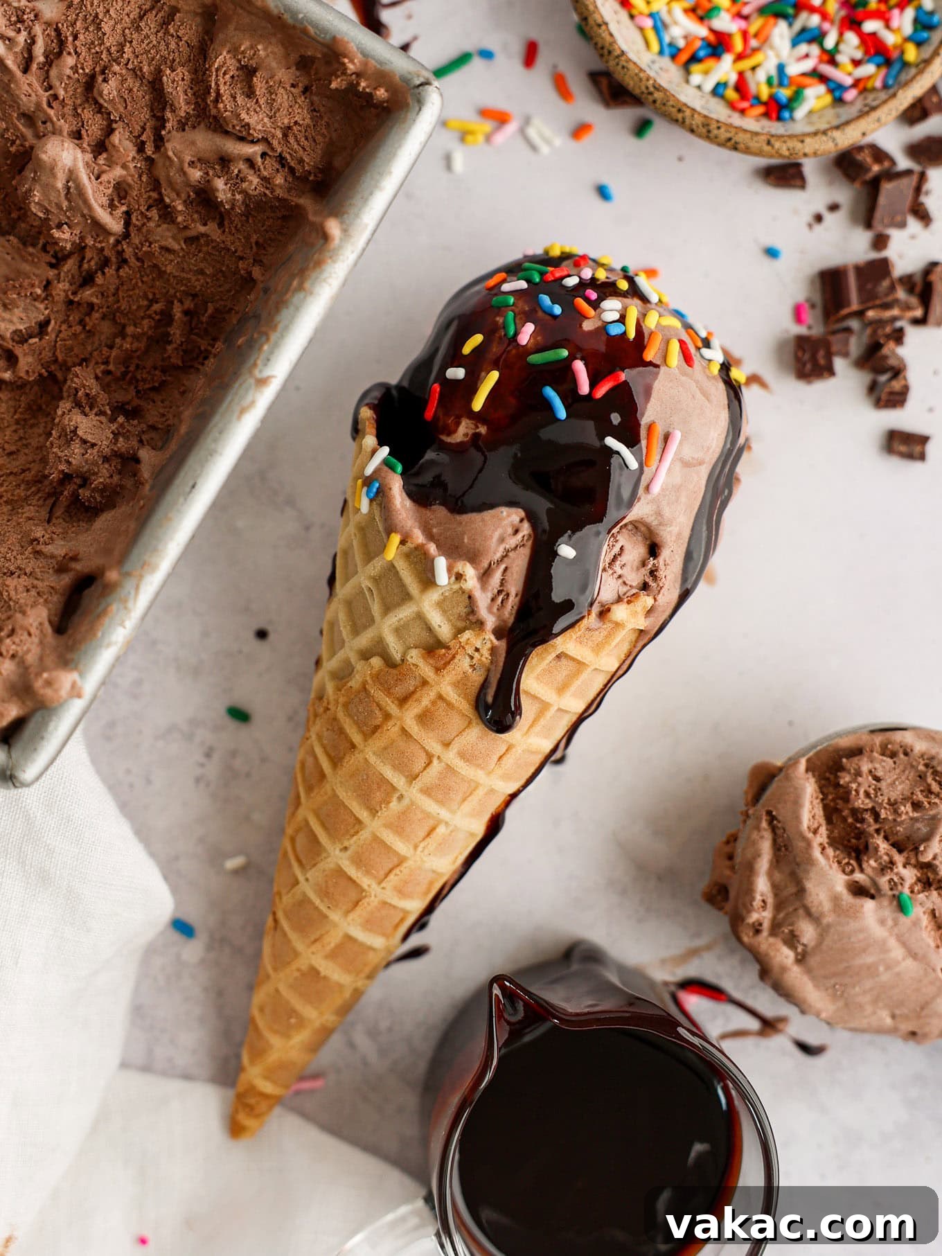 Decadent Chocolate Bliss 9 A chocolate ice cream cone topped with chocolate sauce and colorful sprinkles, resting beautifully on its side.