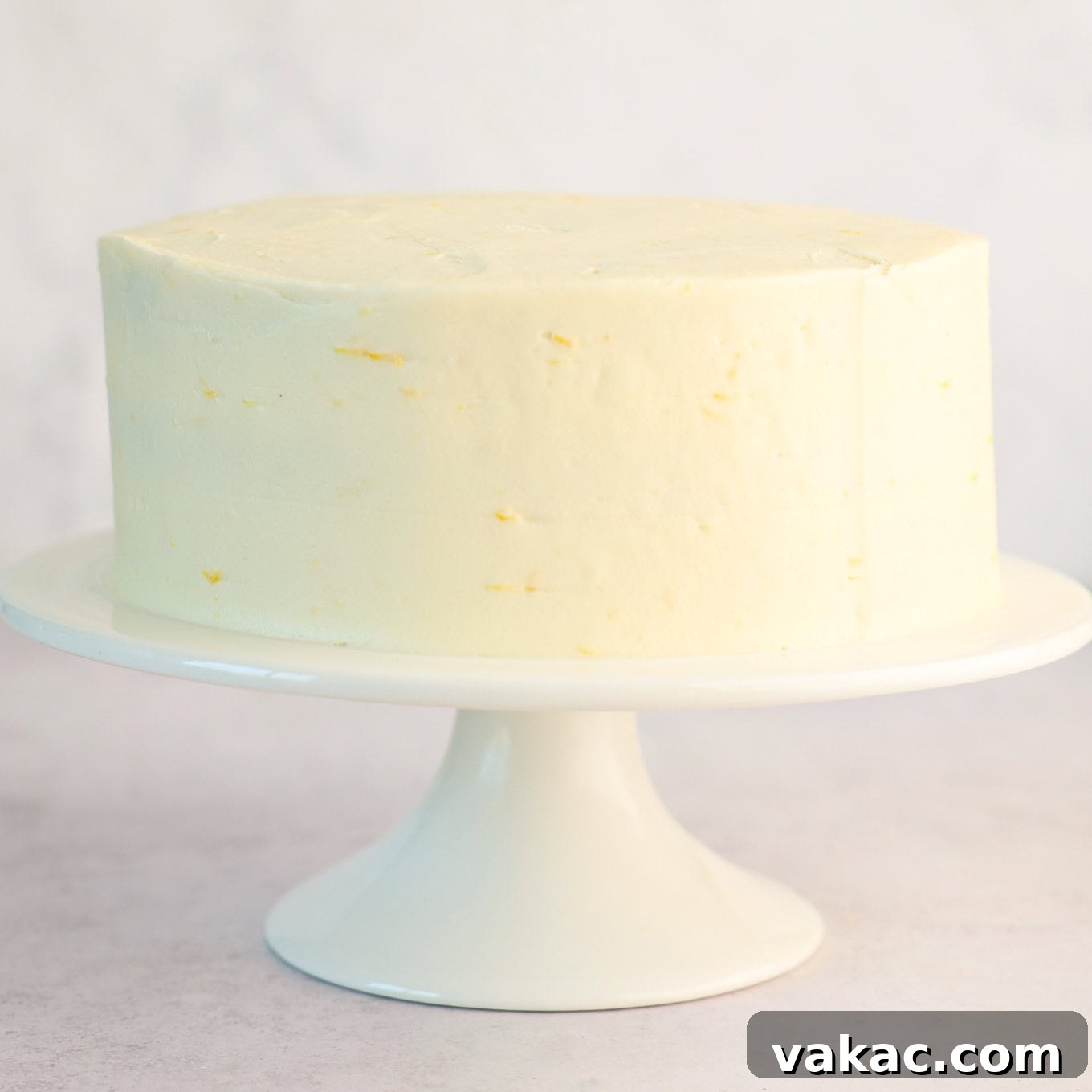 Sunshine Berry Cloud Cake 11 A fully frosted three-layer cake with a smooth, even layer of white cream cheese frosting, awaiting final decorations.