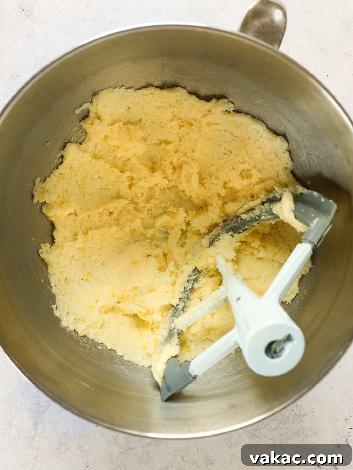 Sunshine Berry Cloud Cake 4 An overhead view of softened butter and granulated sugar being creamed together in a stand mixer with a paddle attachment, showing a light and fluffy texture.