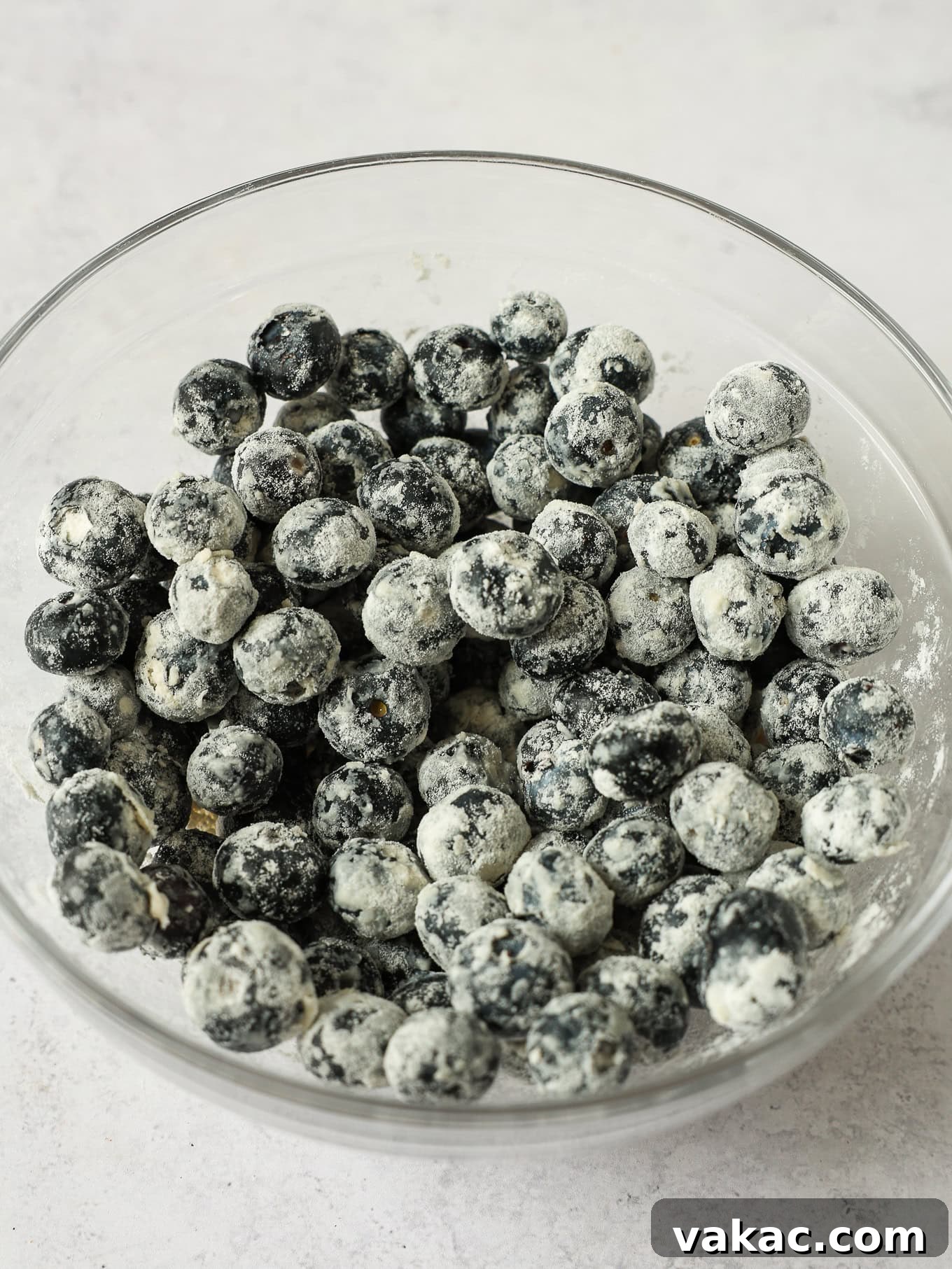 Sunshine Berry Cloud Cake 6 A bowl of fresh blueberries lightly coated in flour, ready to be folded into cake batter.