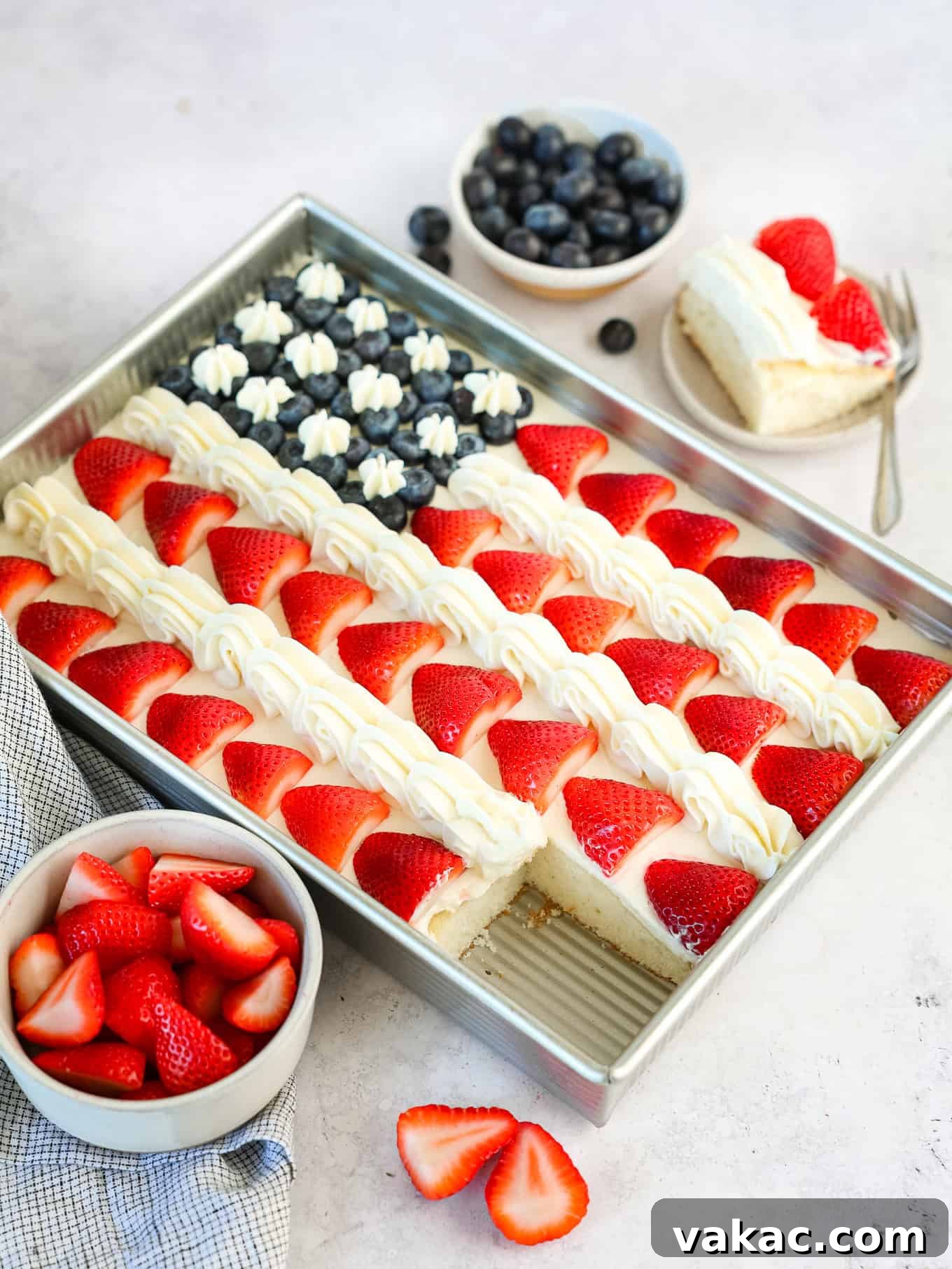 Patriotic Celebration Cake 8 A strawberry and blueberry flag cake with a slice cut out.