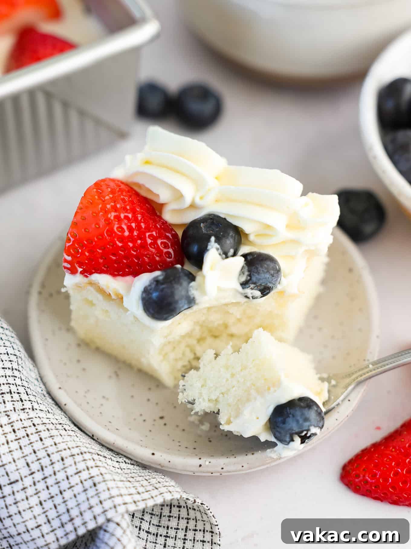 Patriotic Celebration Cake 9 A slice of white cake topped with berries and cream cheese frosting.