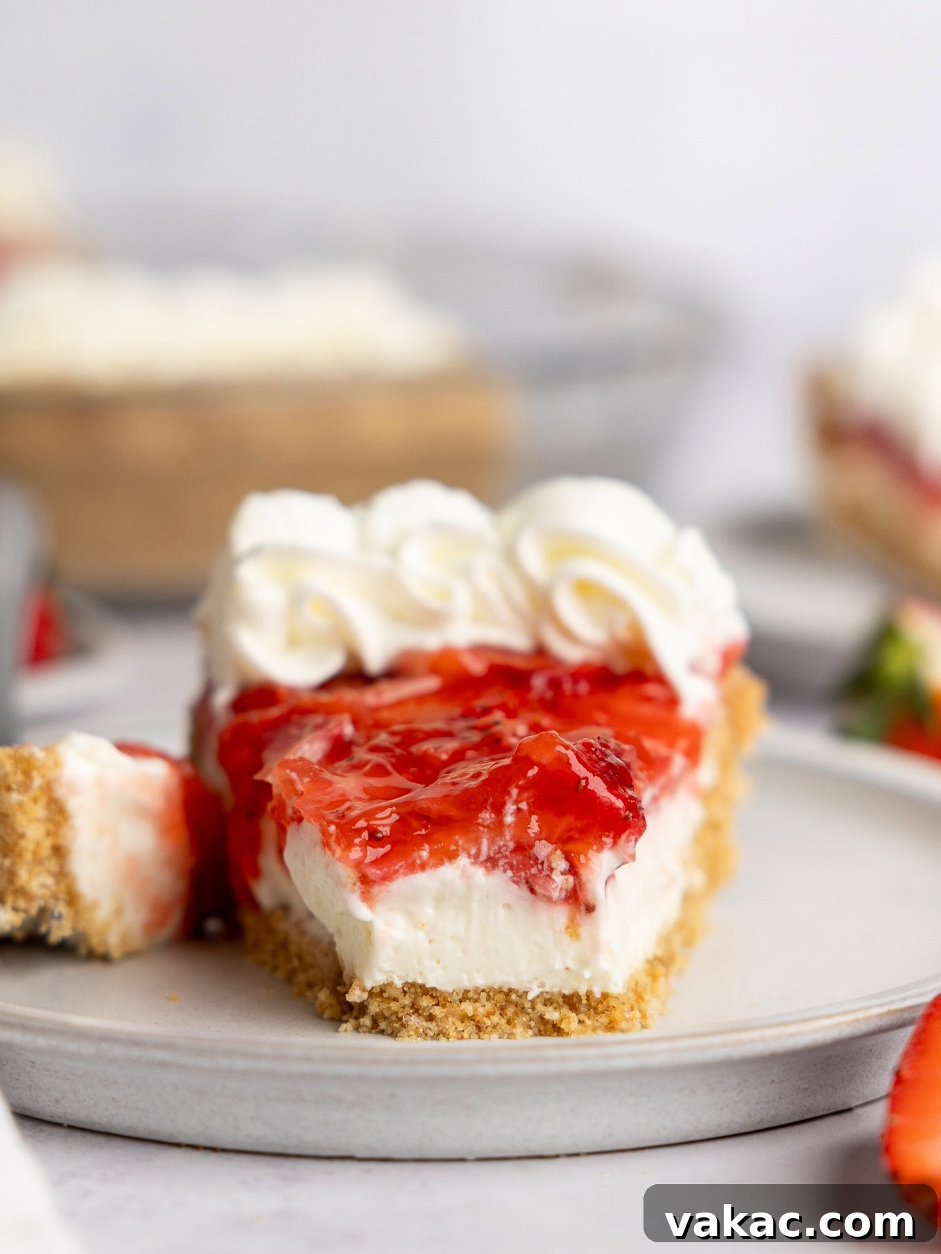 Strawberry Dream Cheesecake 11 A slice of strawberry cream cheese pie, with a bite missing, showing the distinct layers.