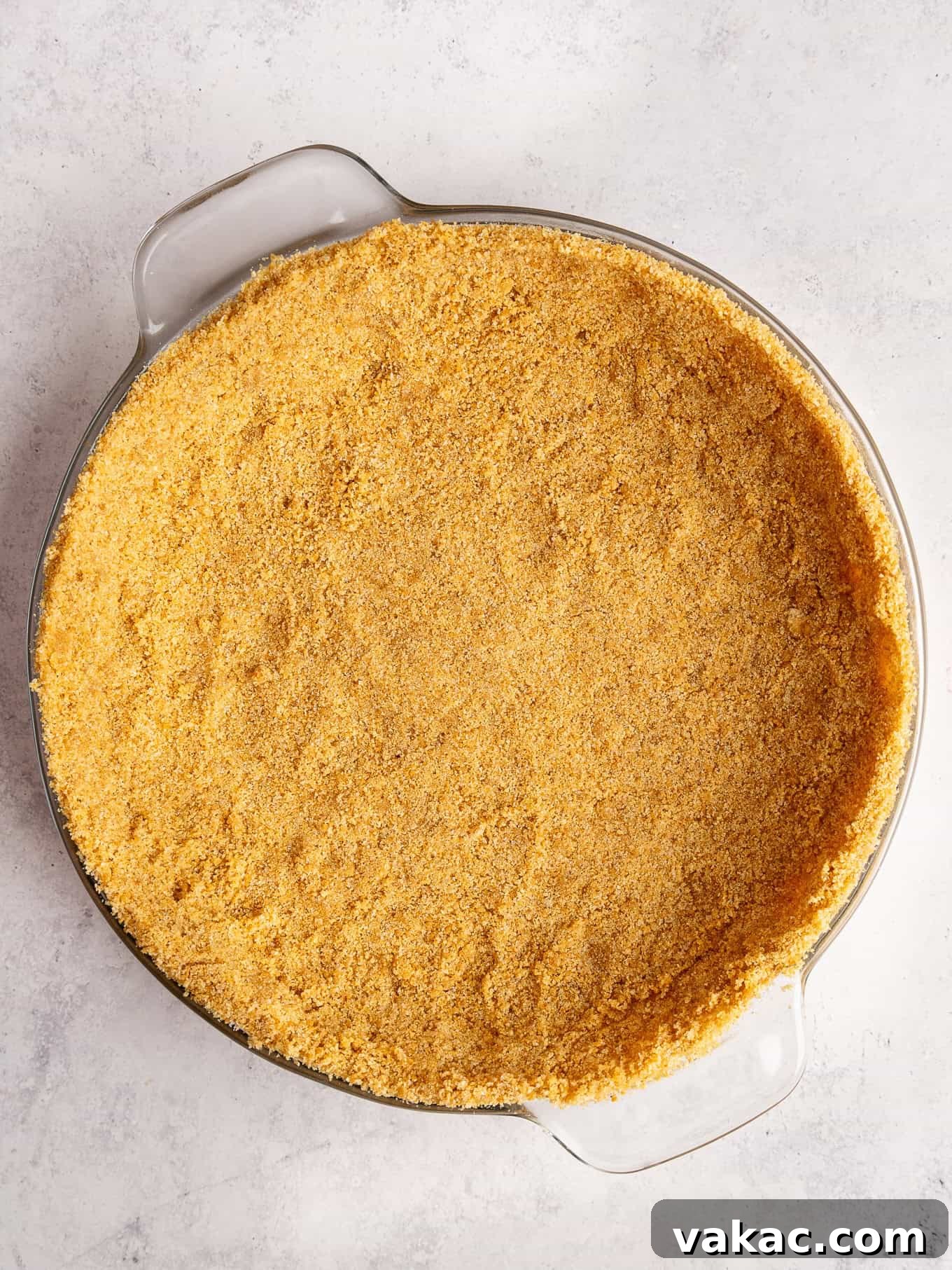 Strawberry Dream Cheesecake 7 An overhead view of a perfectly pressed graham cracker crust in a pie plate.
