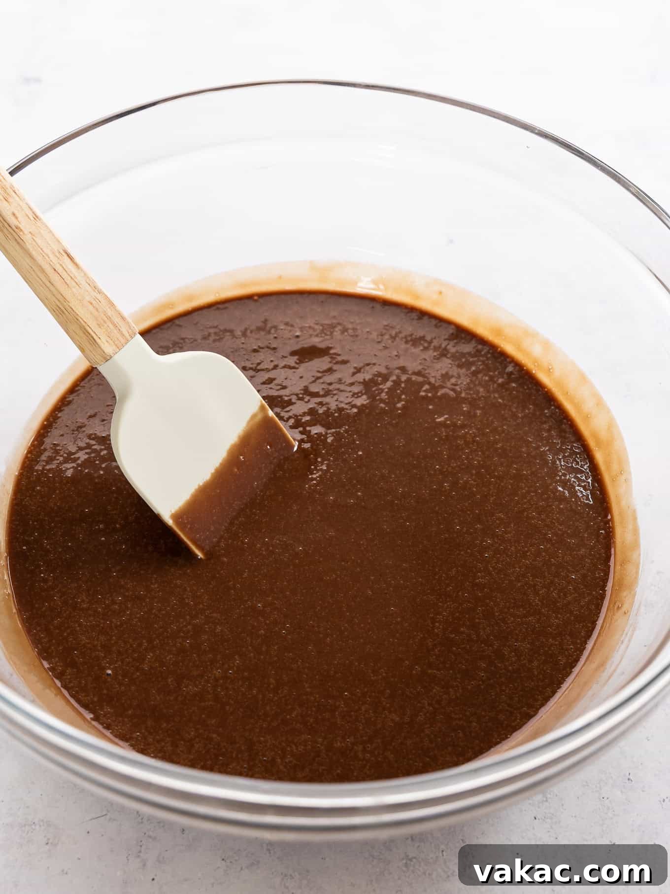 Mini Indulgence 5 Rich, glossy chocolate cake batter in a large mixing bowl, ready to be poured into pans for a small batch chocolate cake.