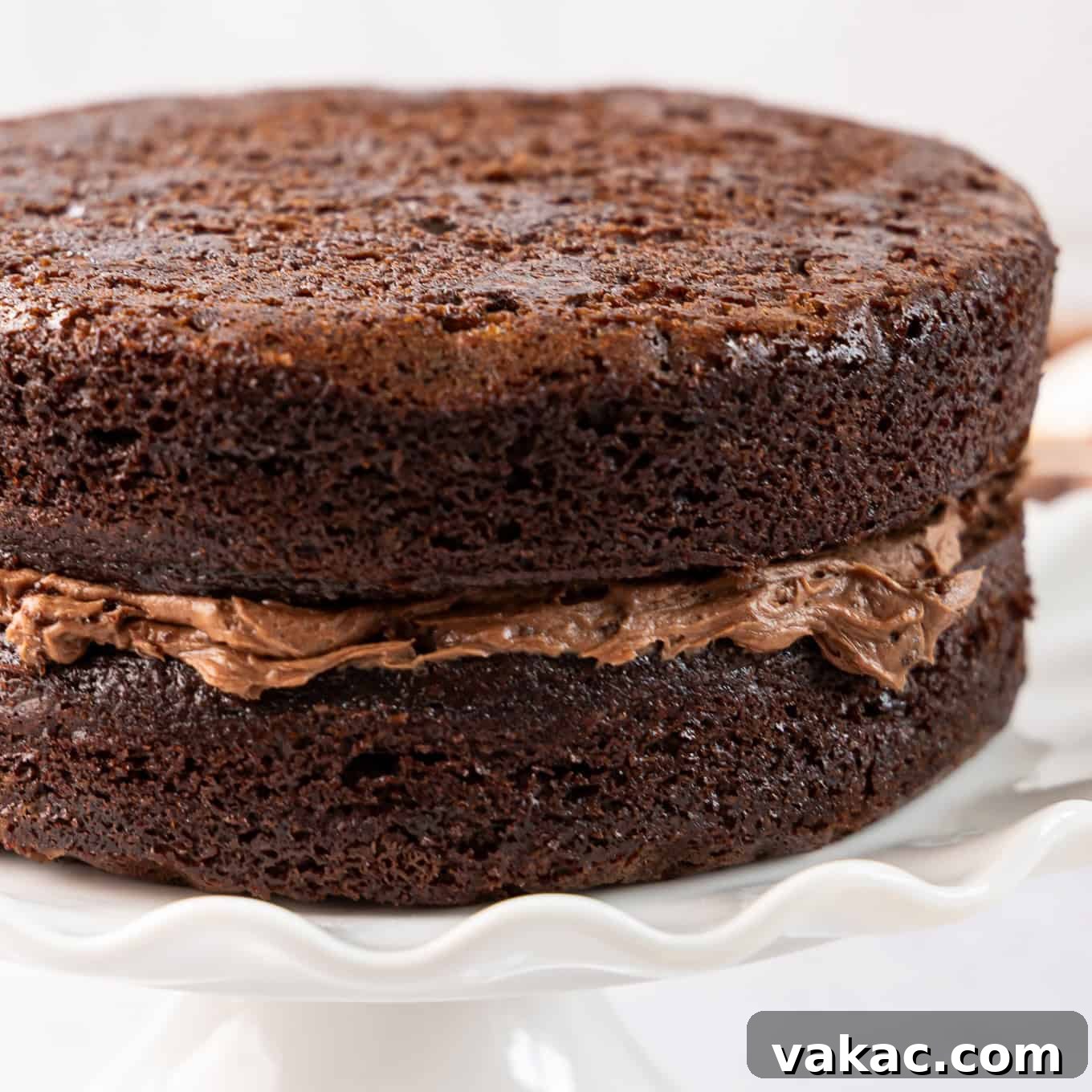 Mini Indulgence 7 Two stacked layers of small chocolate cake with a generous layer of chocolate buttercream frosting in between.