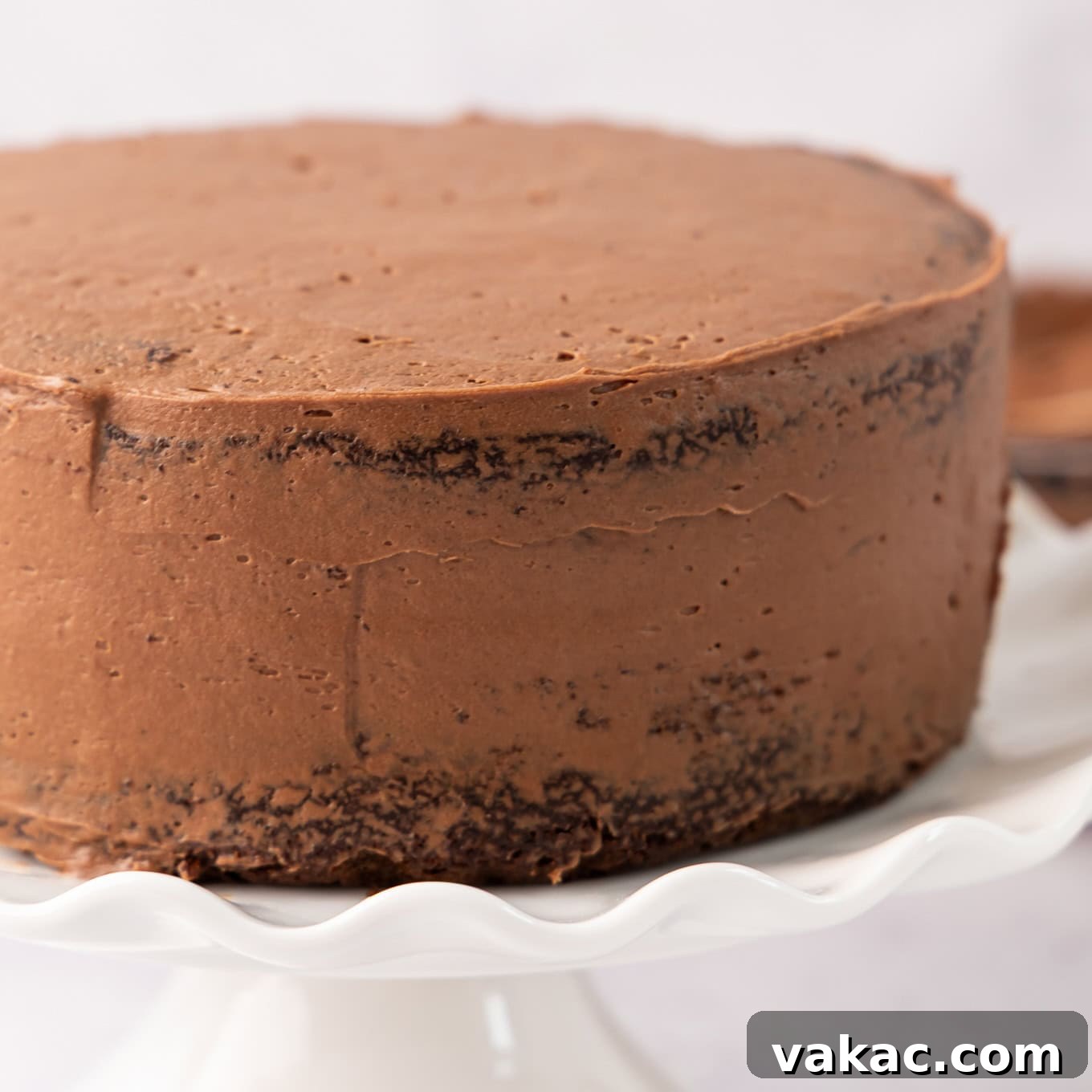 Mini Indulgence 8 A small chocolate cake covered in a thin, even crumb coat of chocolate frosting, chilling to set for a cleaner final frost.