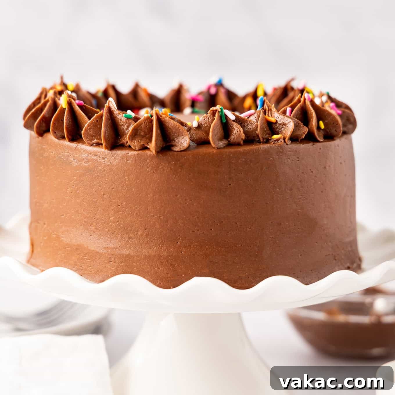 Mini Indulgence 10 A beautifully decorated small chocolate cake with smooth chocolate frosting and colorful sprinkles on top, ready for celebration.