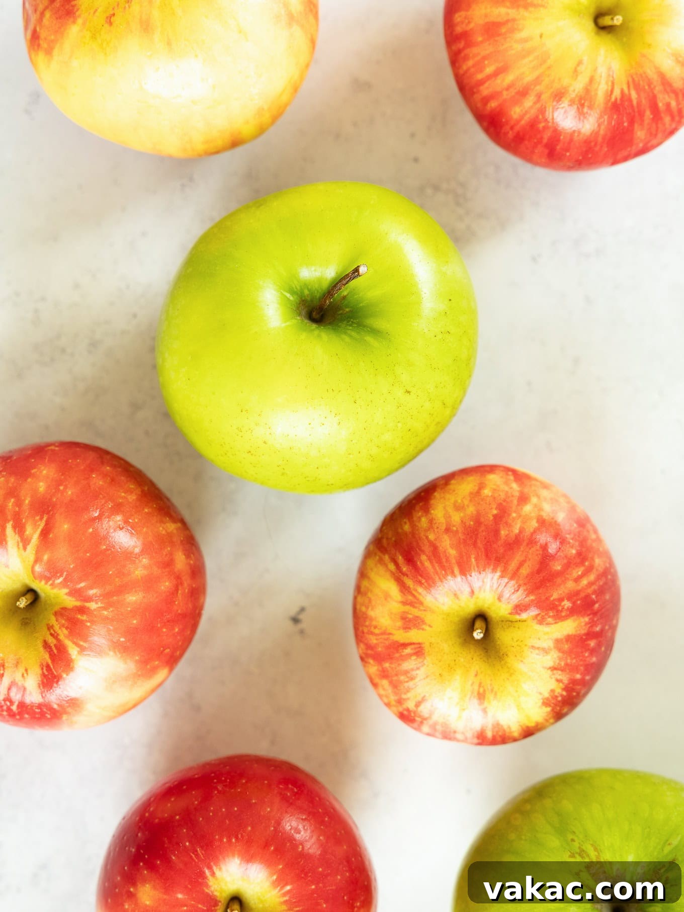 Spiced Apple Fritter Bake 3 Granny Smith and Honeycrisp apples on a counter, ready for baking.