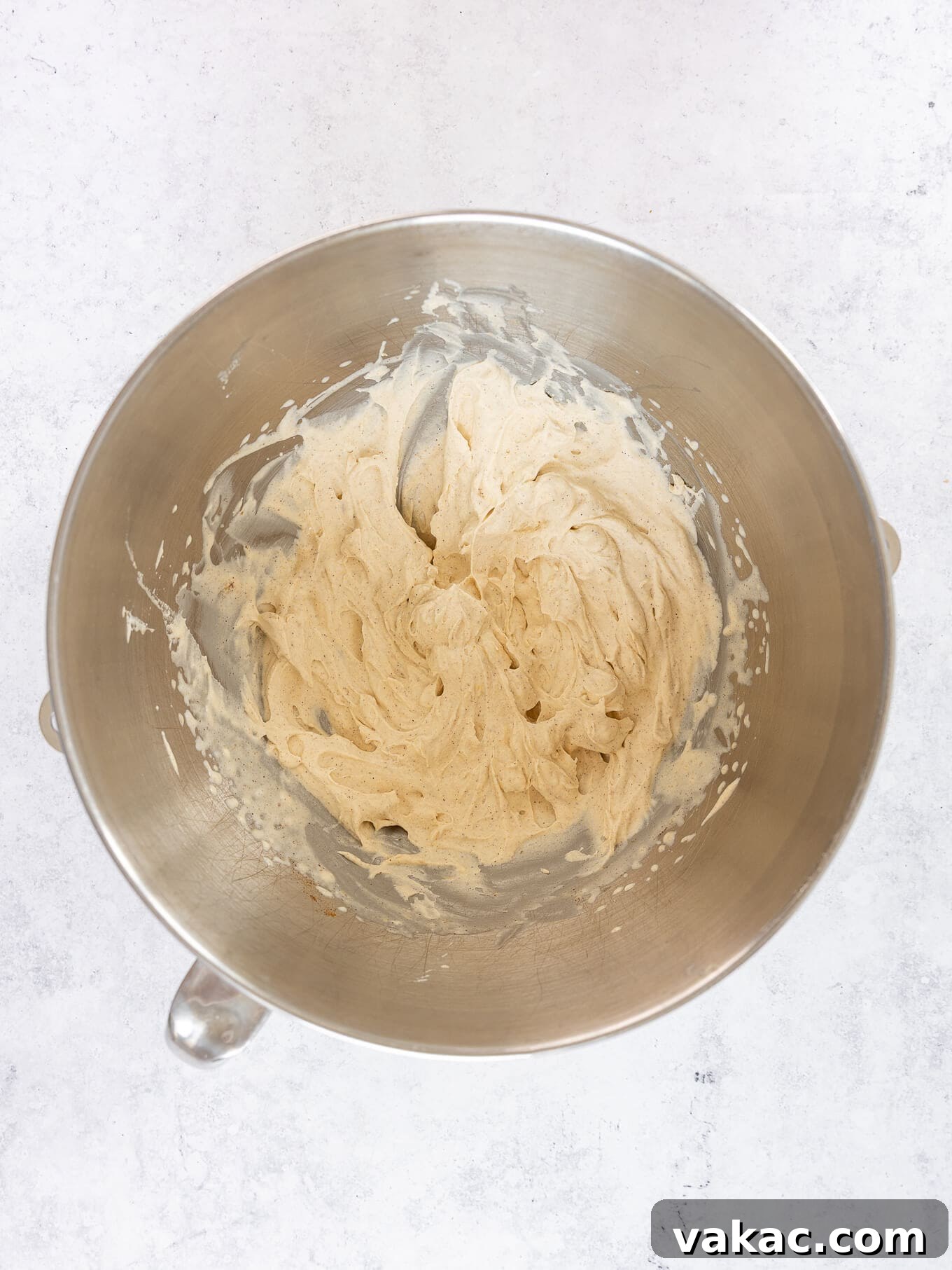 Luxurious pumpkin spice whipped cream, perfectly fluffed and holding stiff peaks in a mixing bowl after proper whipping.