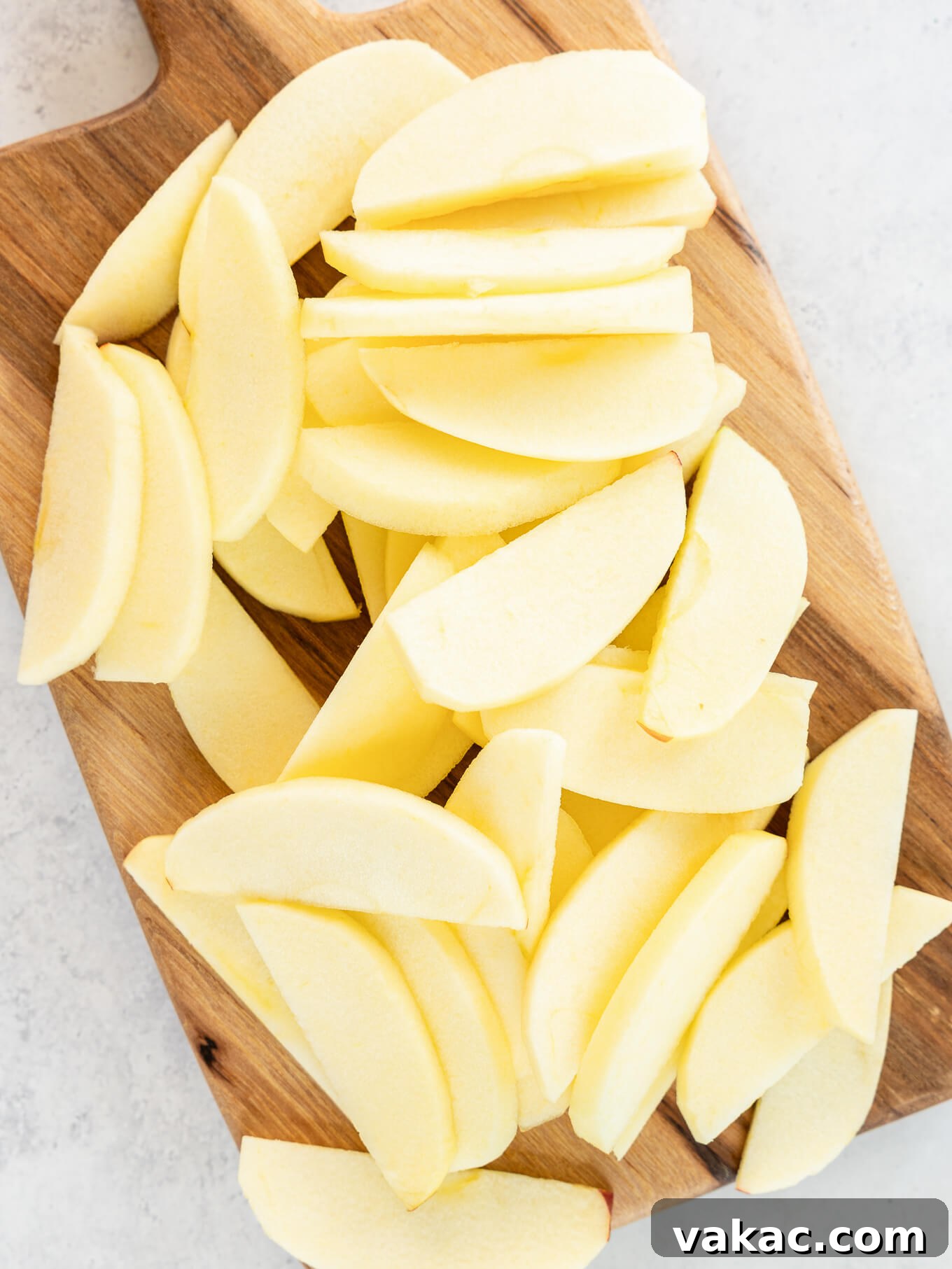 Sweet Skillet Apples 5 Peeled, sliced apples on a cutting board.