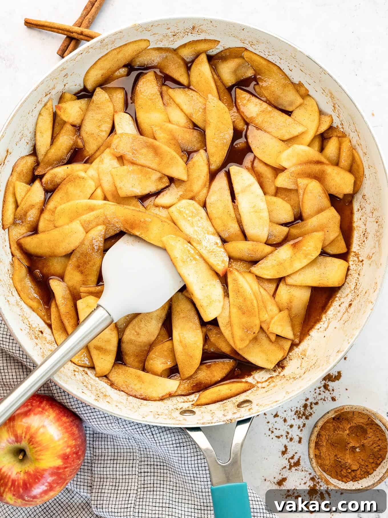 Sweet Skillet Apples 8 An overhead view of fried apples in a skillet with a rubber spatula.