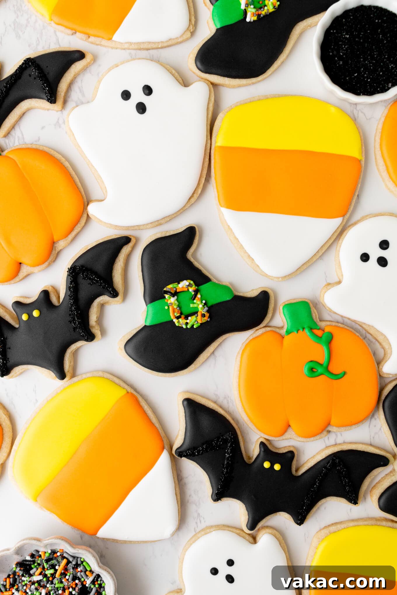 Ghoulishly Good Sugar Cookies 2 An overhead view of intricately iced Halloween sugar cookies in various festive shapes like ghosts, bats, pumpkins, and candy corn.