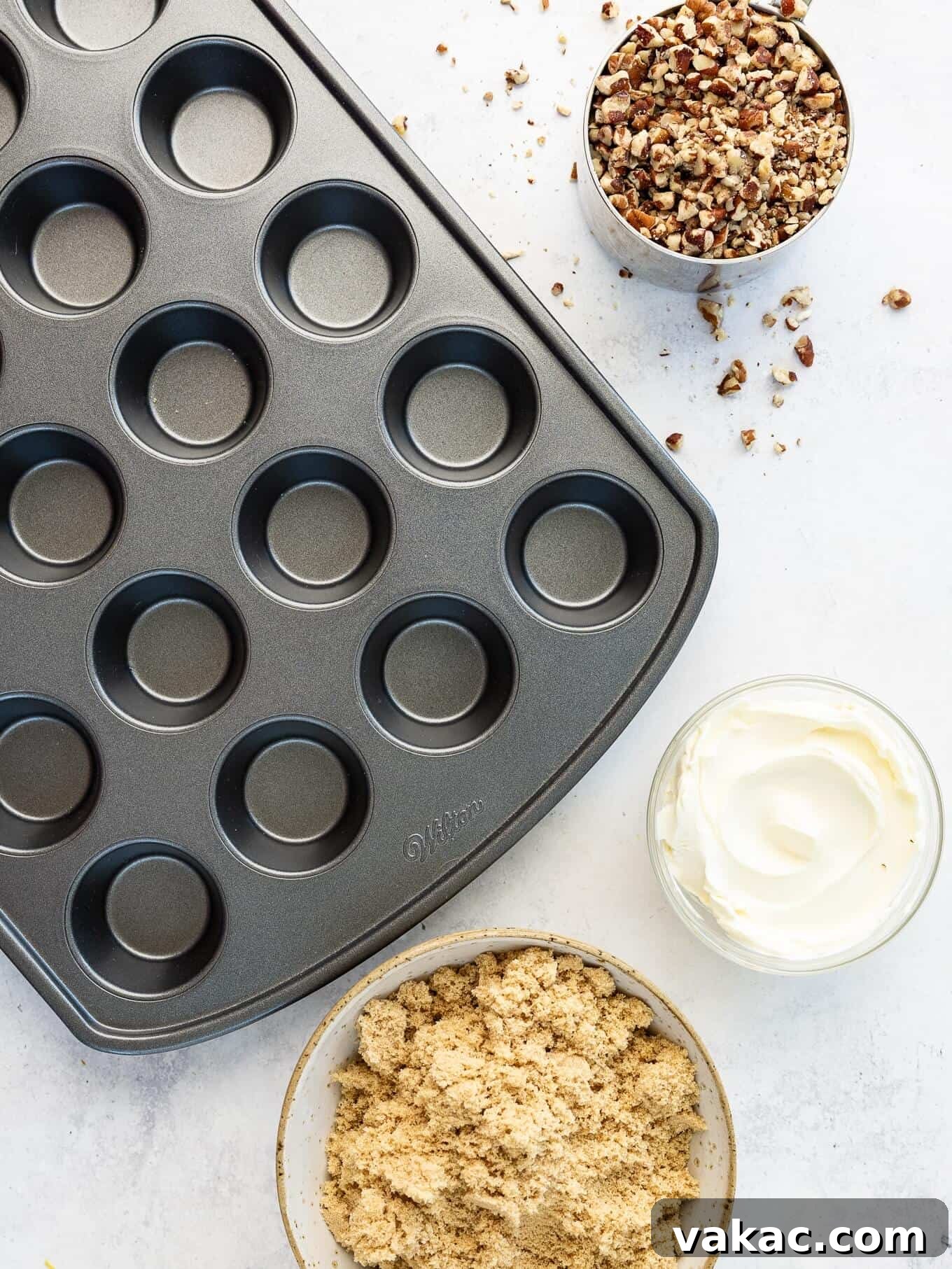 Southern Pecan Treasures 3 An overhead flat lay showing baking ingredients like chopped pecans, a block of cream cheese, brown sugar, and a mini muffin pan, illustrating the simplicity of the recipe's components.