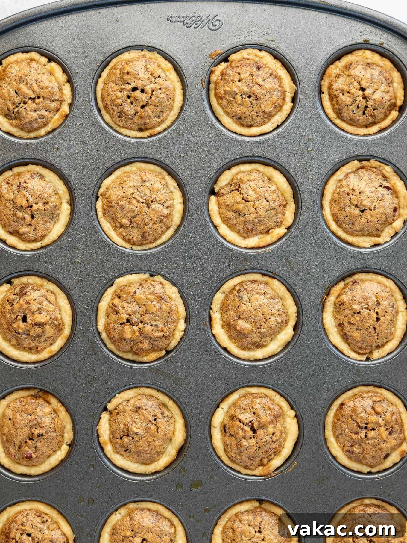Southern Pecan Treasures 7 An overhead view of pecan tassies in a mini muffin pan, filled with the golden-brown pecan mixture, ready for the oven or freshly baked.