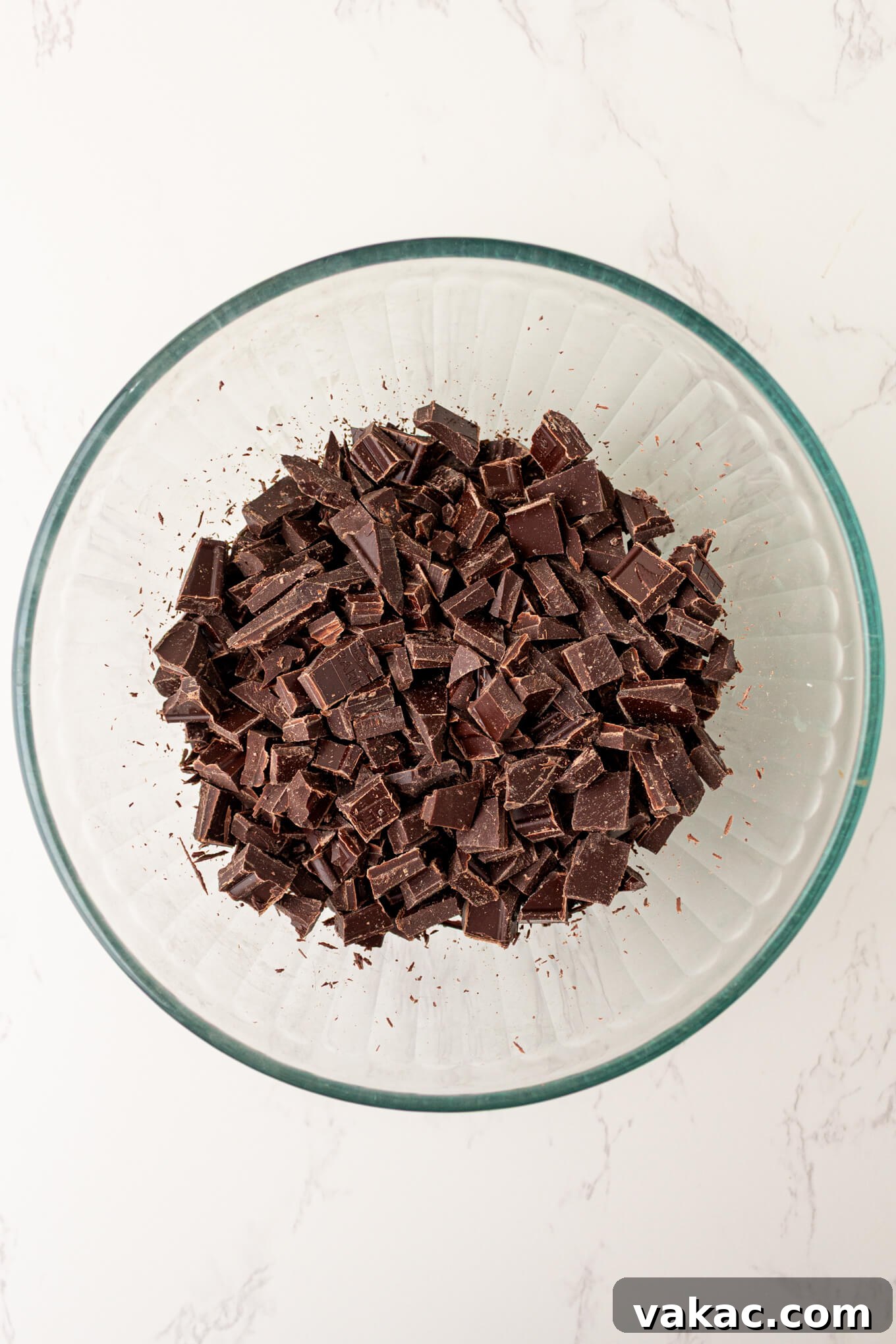 Twisted Chocolate Indulgence 4 Finely chopped chocolate in a clear glass bowl, ready for melting.