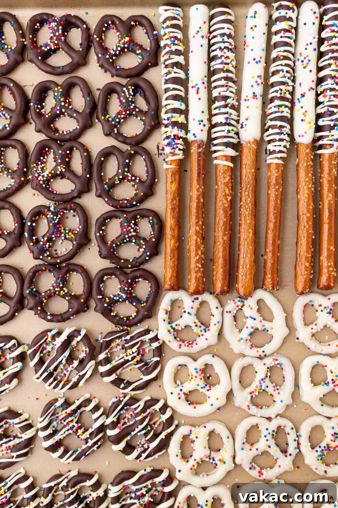Twisted Chocolate Indulgence 9 An overhead view of freshly made chocolate covered pretzels and pretzel rods, topped with sprinkles, arranged neatly on parchment paper.