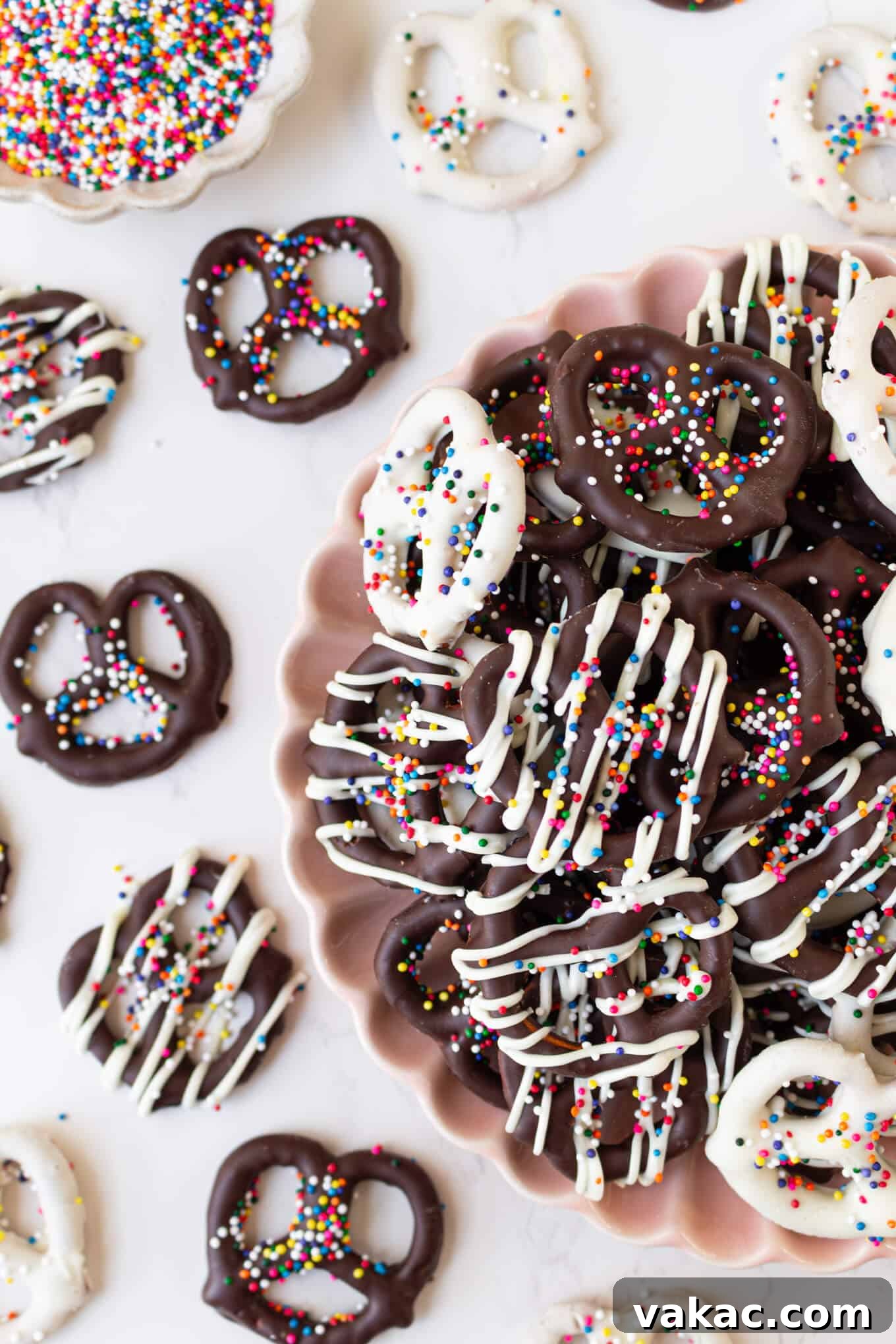 Twisted Chocolate Indulgence 10 An overhead view of a pile of beautifully decorated chocolate covered pretzels in a delicate pink bowl.