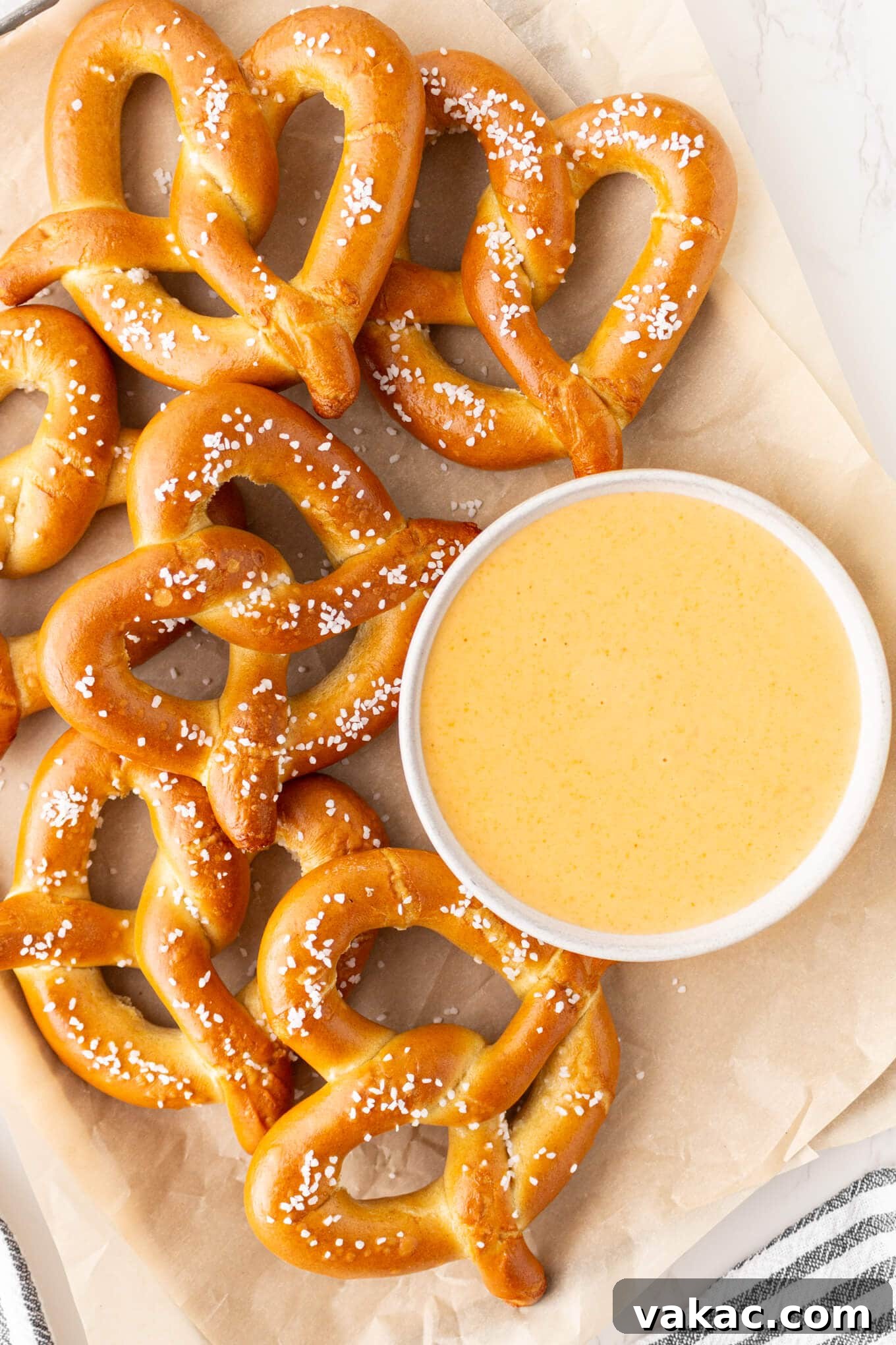 Golden Beer Cheese Dip 2 An overhead view of soft pretzels with a bowl of beer cheese dip, ready to be enjoyed.