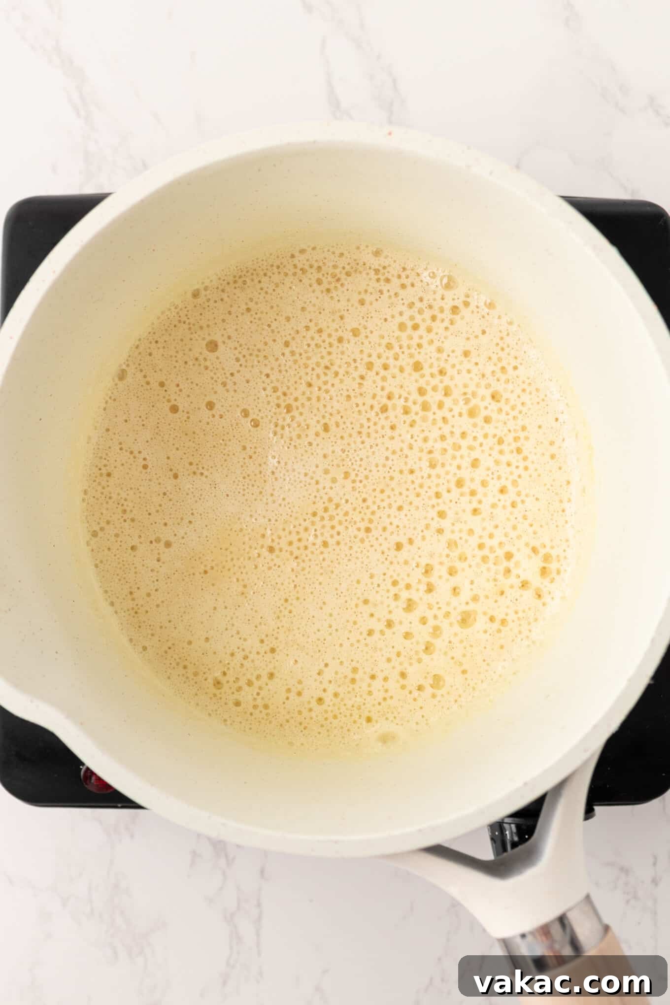 Golden Beer Cheese Dip 4 An overhead view of a butter and flour roux thickening in a saucepan, forming the base of the dip.