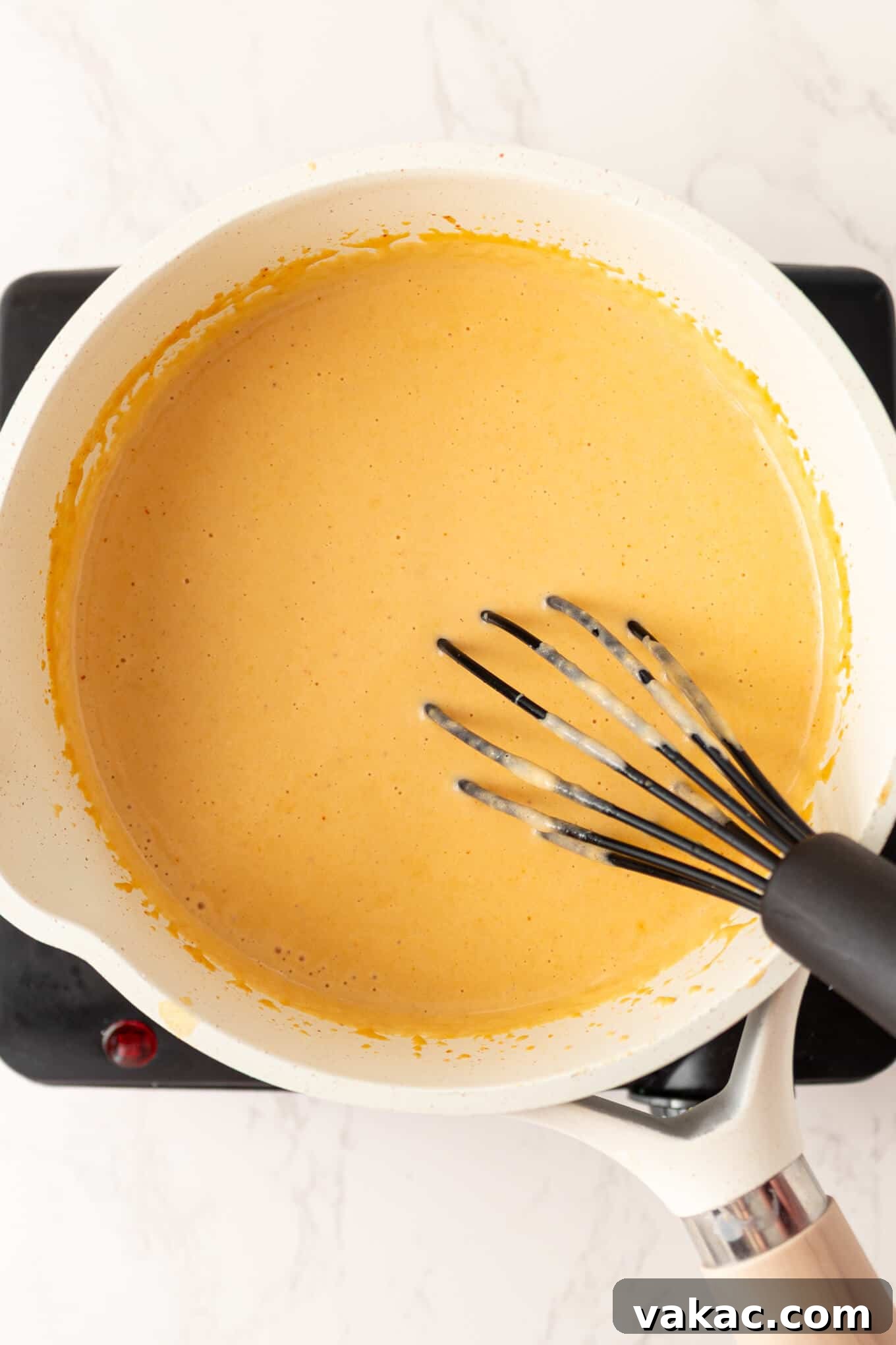 Golden Beer Cheese Dip 5 An overhead view of the bubbling, hot beer cheese dip in a saucepan, almost ready to serve.