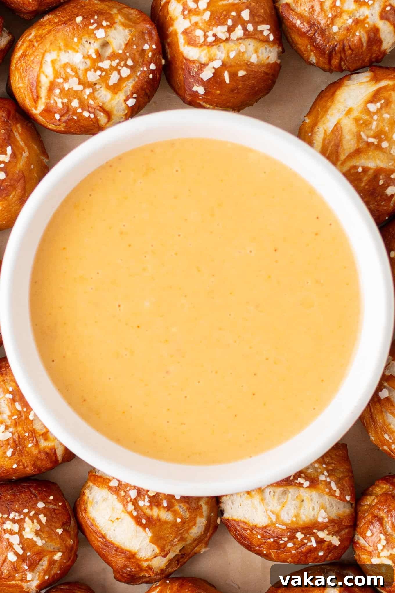 Golden Beer Cheese Dip 7 A beautifully presented bowl of creamy beer cheese dip, surrounded by an inviting array of soft pretzel bites.