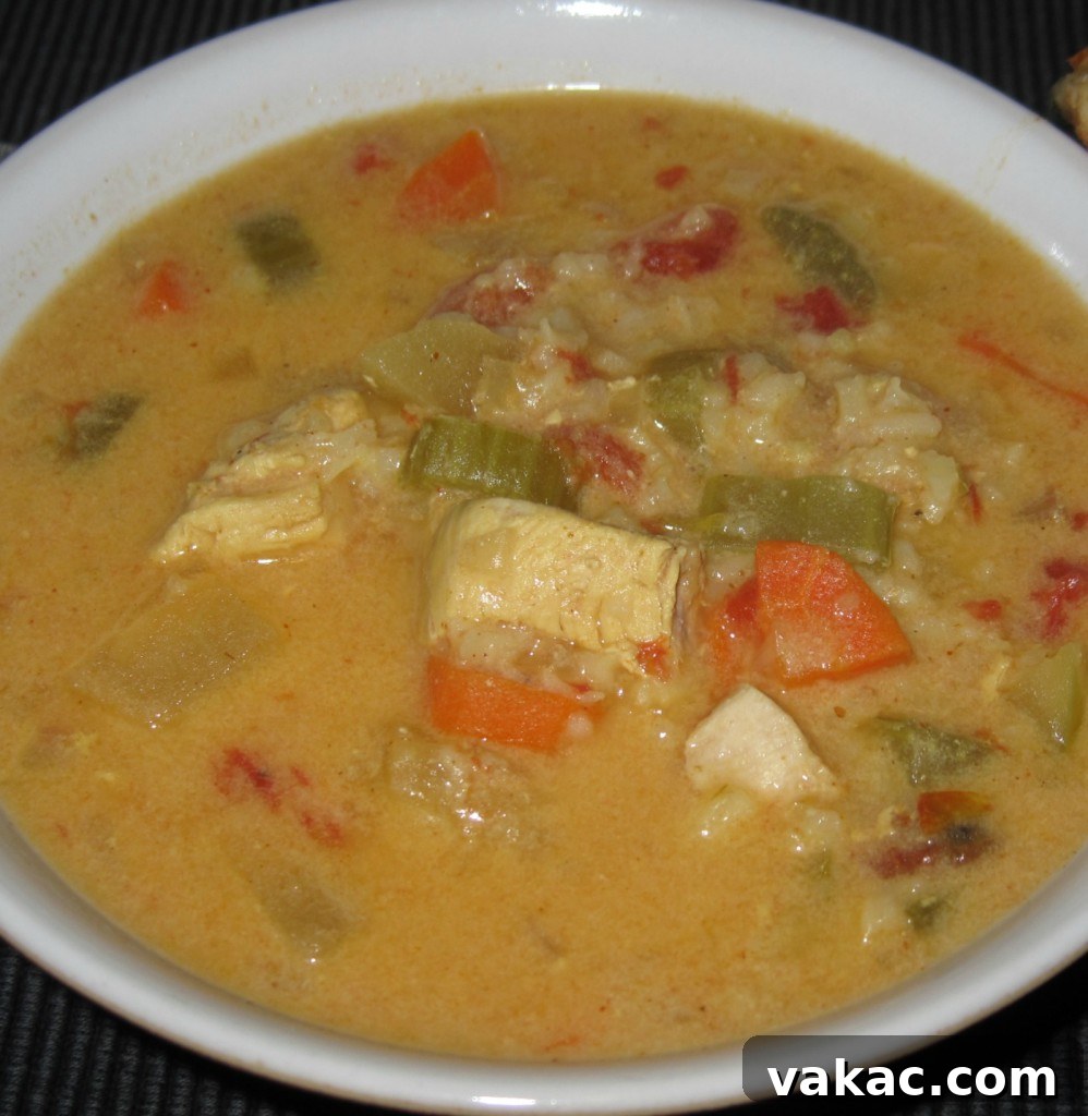 mulligatawny soup crop A hearty bowl of Mulligatawny soup with chicken, vegetables, and a creamy texture, garnished with fresh herbs, suitable for a comforting and nutritious meal.