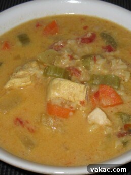 Close-up of a serving of Mulligatawny soup, highlighting the rich texture and vibrant ingredients.