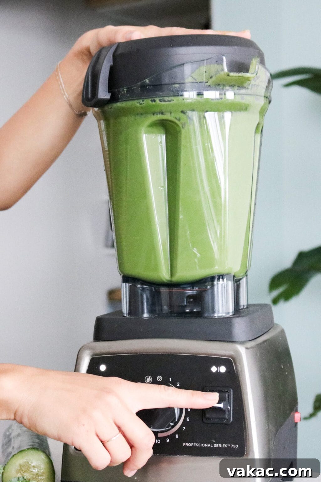 A high-powered blender filled with the green juice ingredients, ready to be blended.