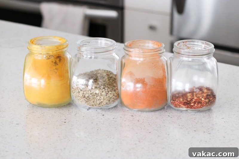 10 Essential Spices to Elevate Your Everyday Cooking 3 A selection of vibrant spices, including a golden pile of turmeric, red paprika, and other earthy tones, arranged on a dark background, highlighting their rich colors and textures.