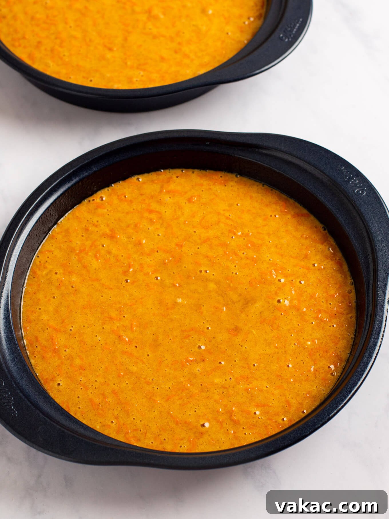 Carrot cake batter poured into two 9-inch round cake pans.