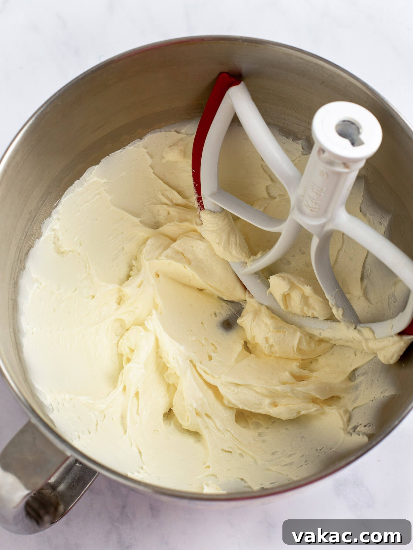 Cream cheese and butter mixed together in the bowl of a stand mixer.