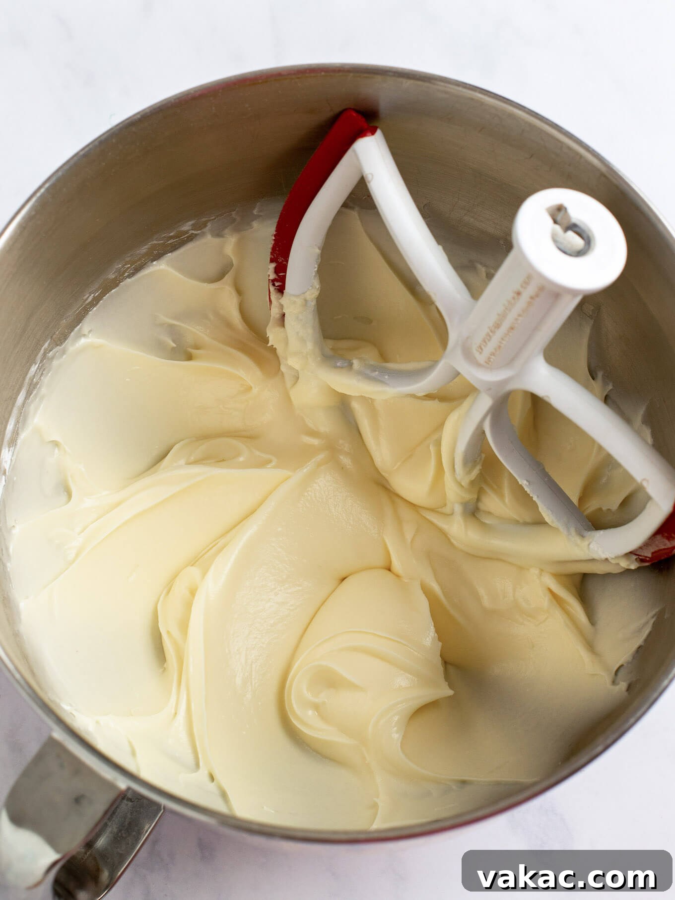 Cream cheese frosting fully mixed together in the bowl of a stand mixer.