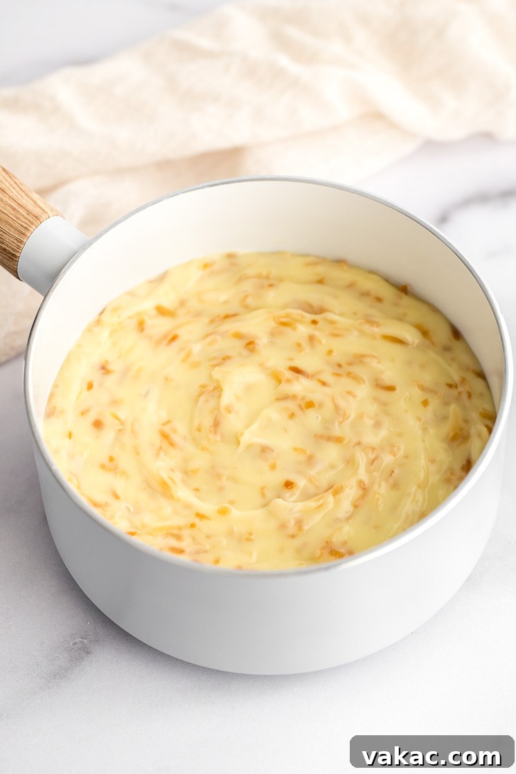 A picture of coconut cream pie filling in a white saucepan. 