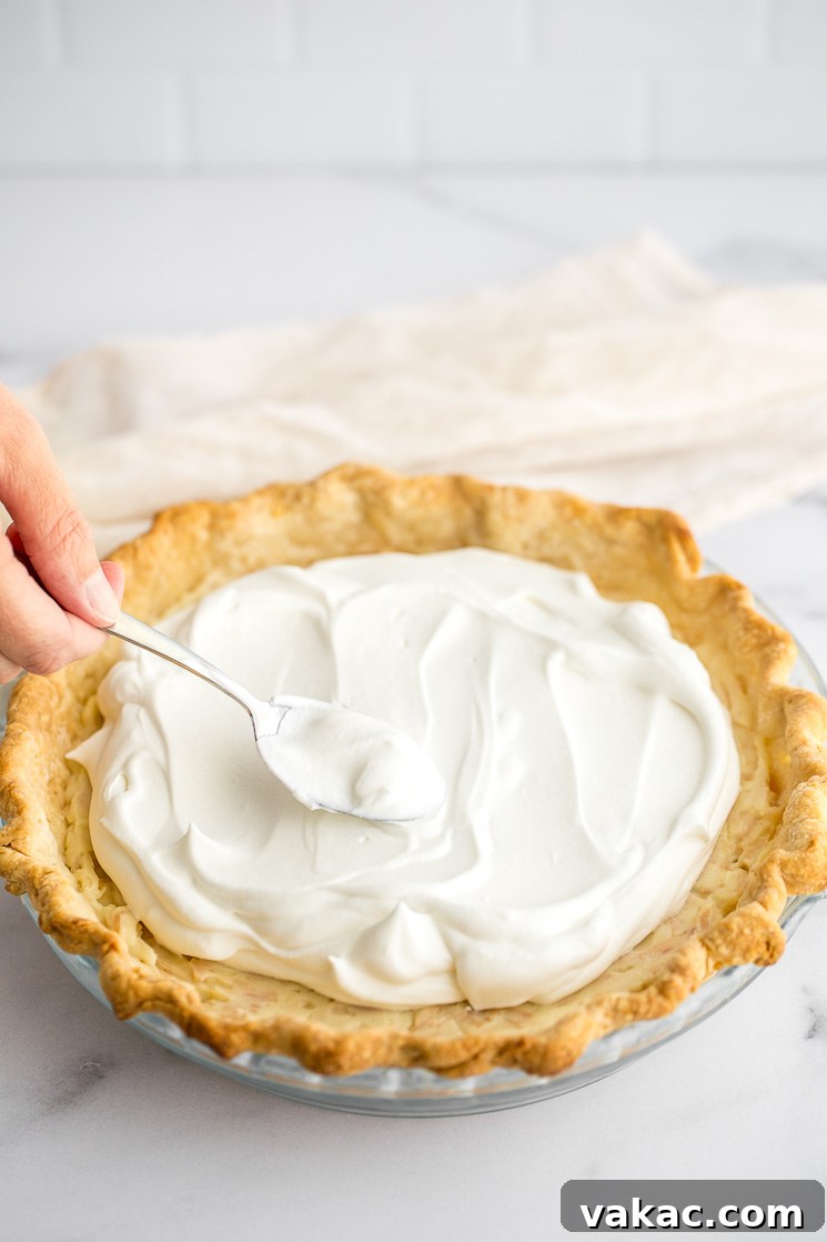 A close-up of whipped cream being added to the top of the pie.