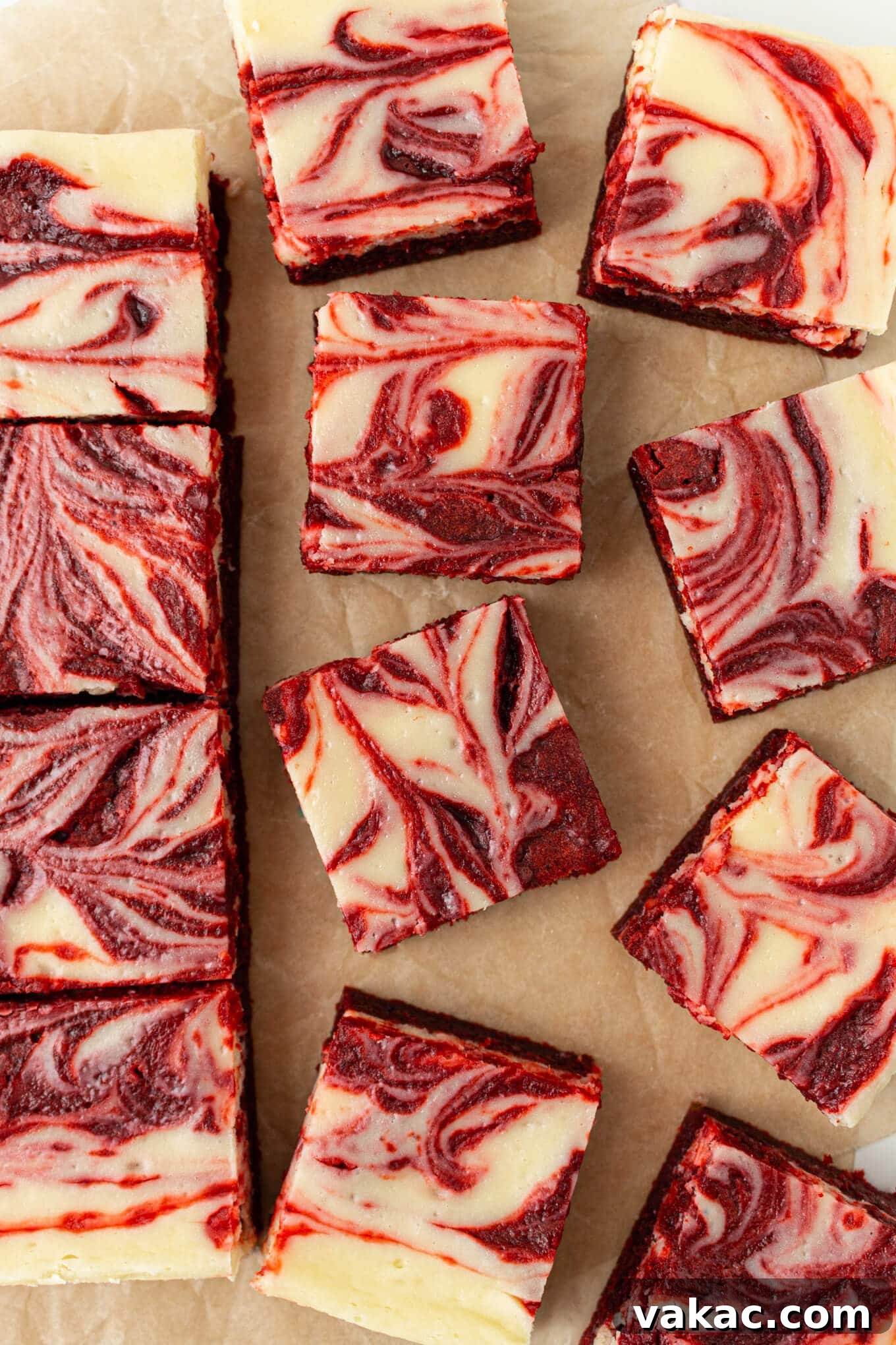 Crimson Cheesecake Brownie Bliss 2 An overhead view of perfectly sliced red velvet cheesecake brownies, showing the rich red and creamy white swirl pattern.