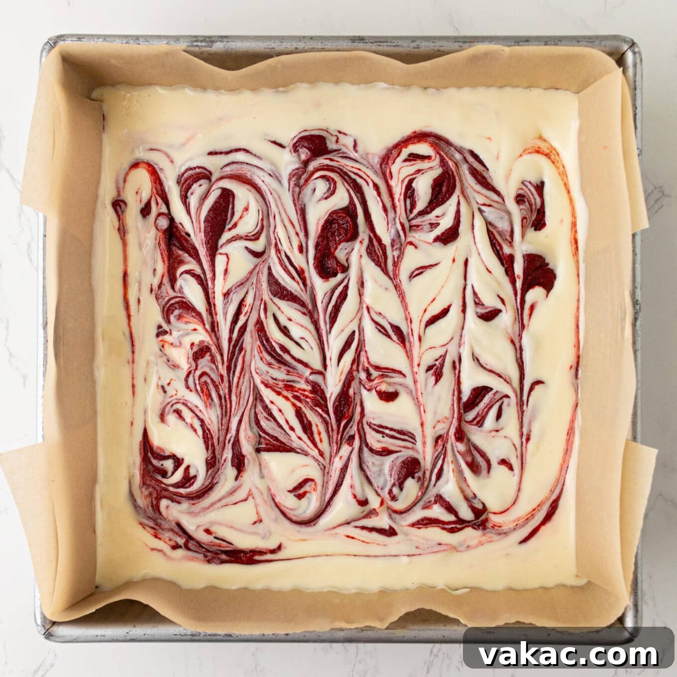 Crimson Cheesecake Brownie Bliss 6 The artistic swirl pattern created on the red velvet cheesecake brownies, ready to be baked to perfection.