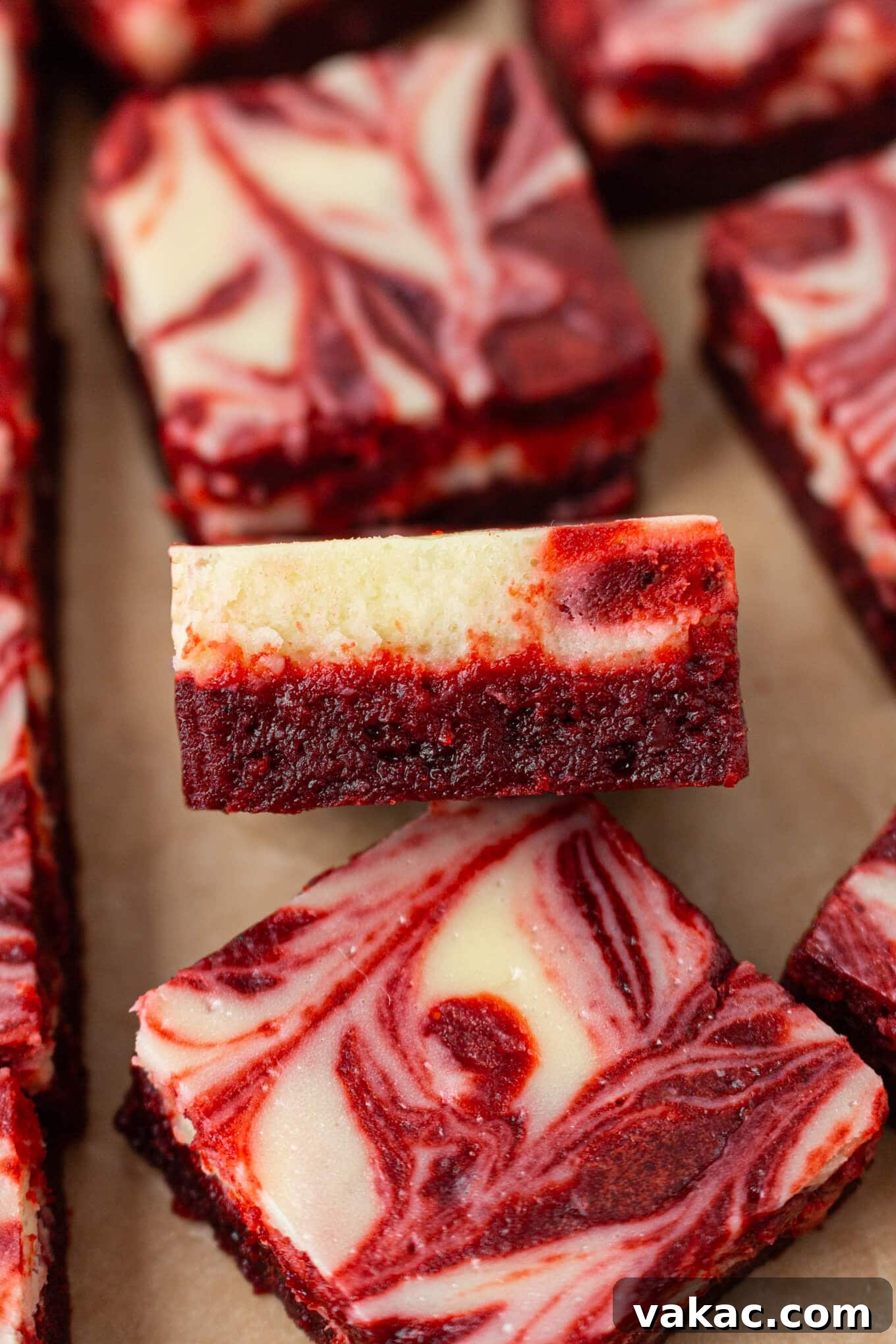 Crimson Cheesecake Brownie Bliss 7 A perfectly cut slice of red velvet cheesecake brownie, leaning on another, highlighting its fudgy texture and distinct swirl.