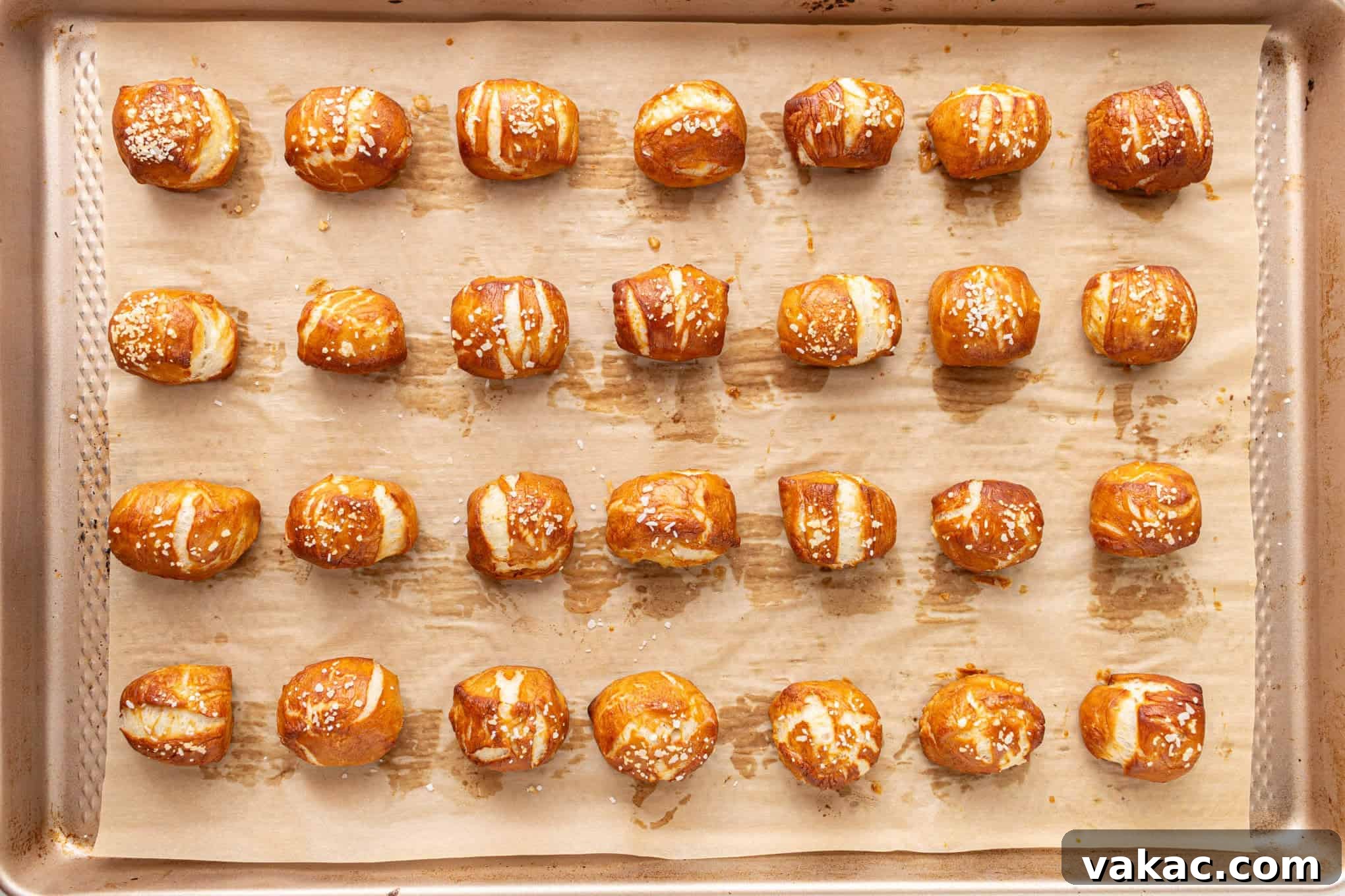 Pillowy Pretzel Gems 8 A baking sheet filled with golden-brown soft pretzel bites, glistening and freshly baked, ready to be served.