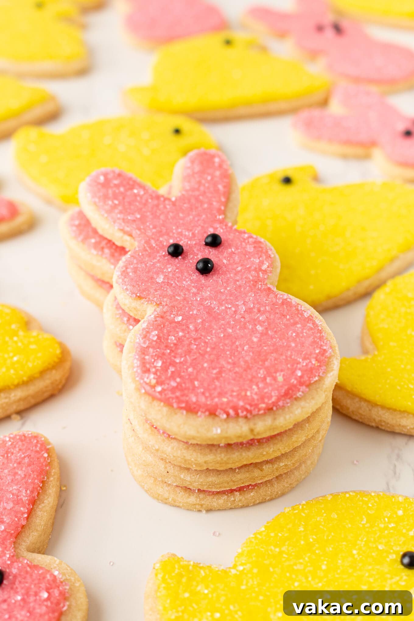 Hoppy Easter Cookies 11 A neat stack of tender, soft Easter bunny cookies, each perfectly iced in pink and coated with sparkling sanding sugar, creating an inviting visual.