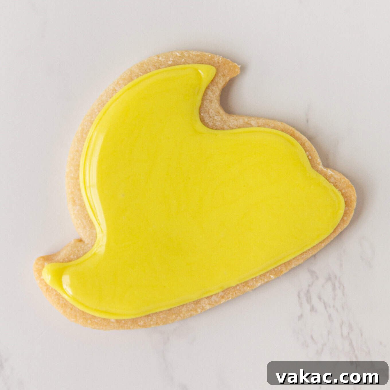 Hoppy Easter Cookies 7 A process shot depicting a chick sugar cookie fully flooded with yellow icing, showcasing a smooth, even layer covering the entire surface.