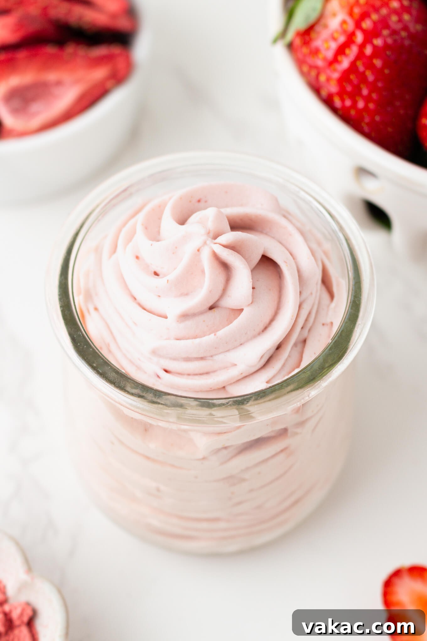 Strawberry Cloud Perfection 2 A glass jar of piped strawberry whipped cream, showcasing its light pink hue and fluffy texture.