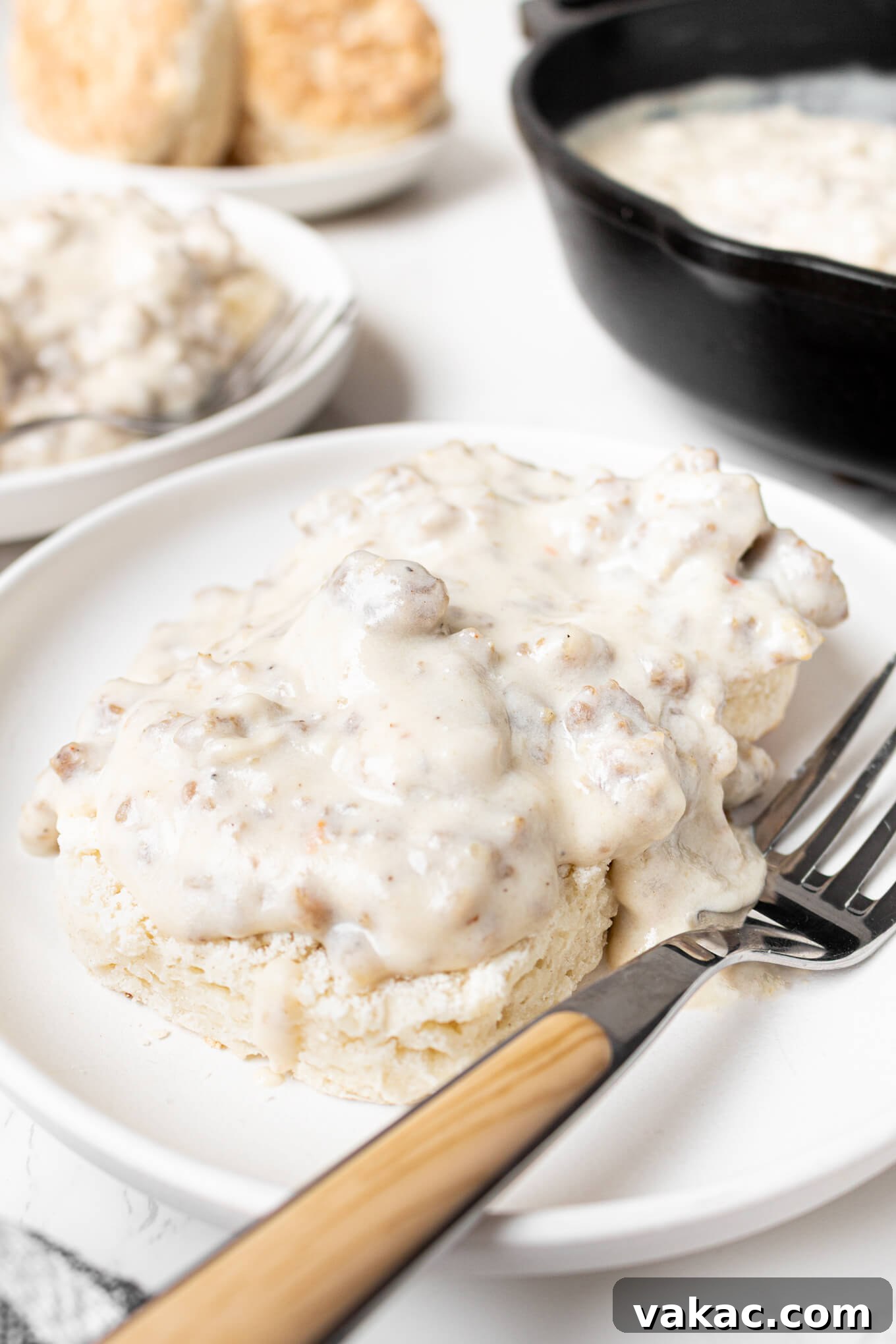 Southern Sausage Gravy Recipe for Biscuits and Breakfast 6 A biscuit smothered in sausage gravy on a plate.