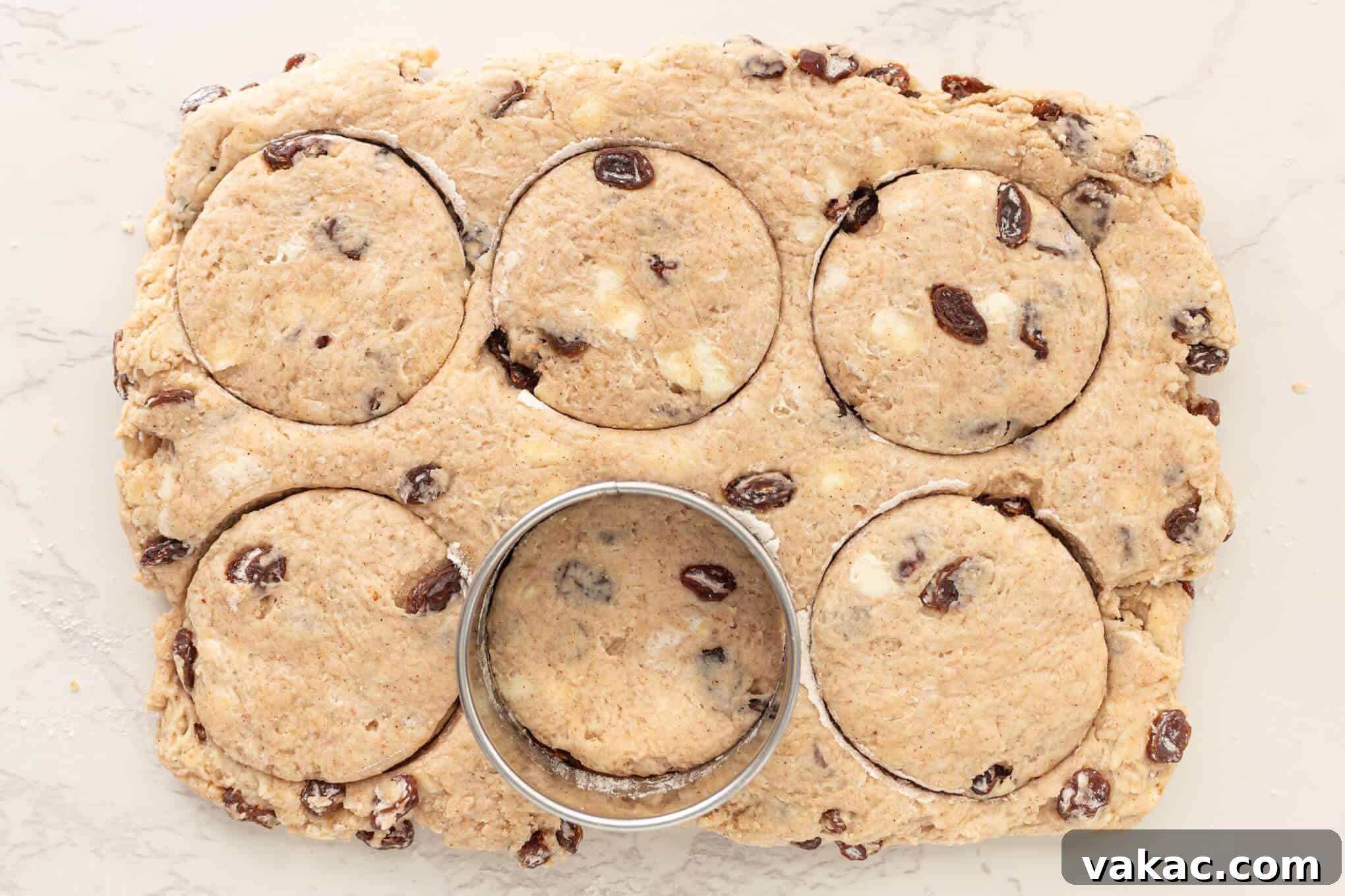 Fluffy Cinnamon Raisin Biscuits with Brown Sugar Glaze 8 An overhead view of cinnamon raisin biscuit dough being cut out.