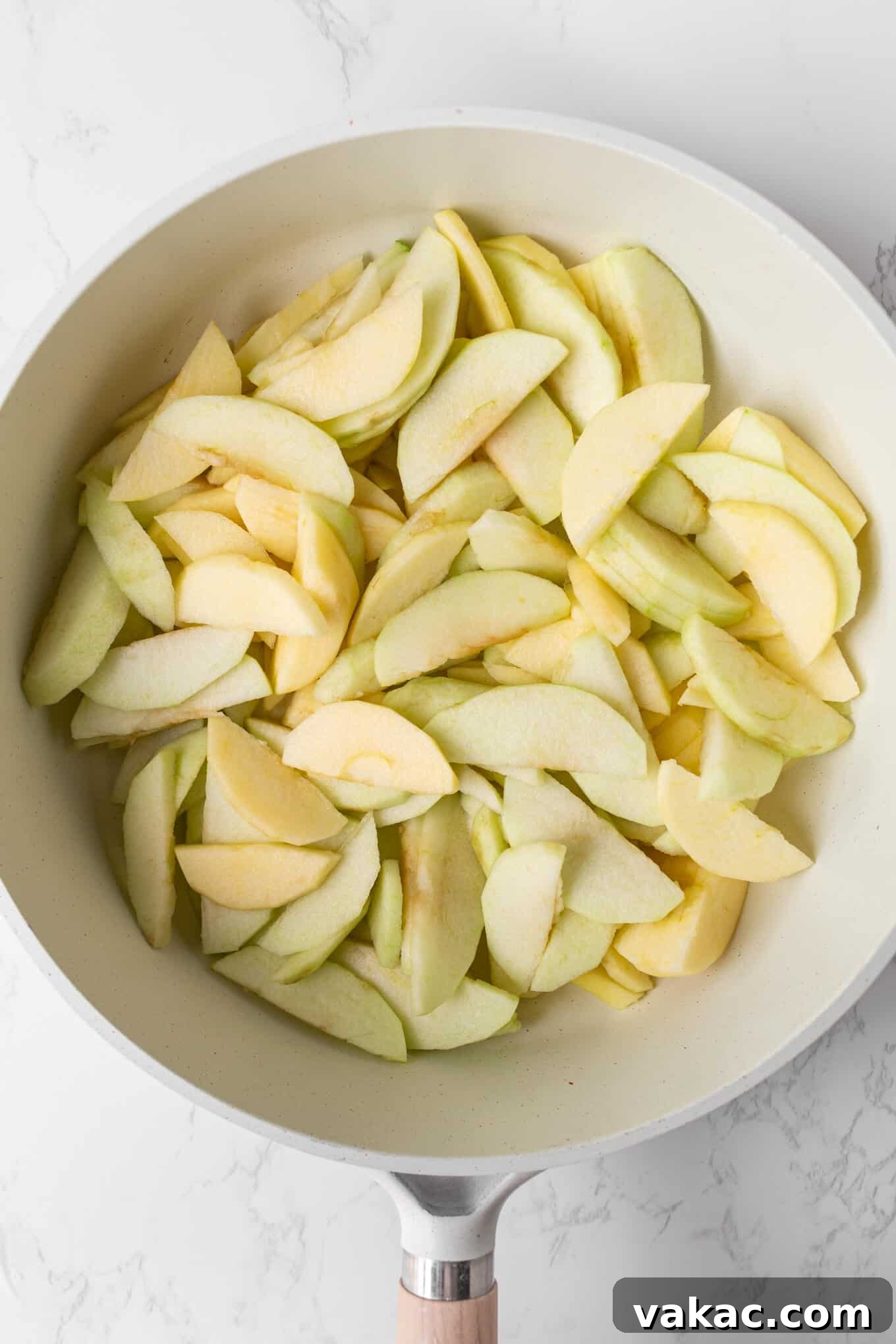 Classic Apple Cobbler with Cinnamon Crumble 4 An overhead view of apple slices in a saucepan.