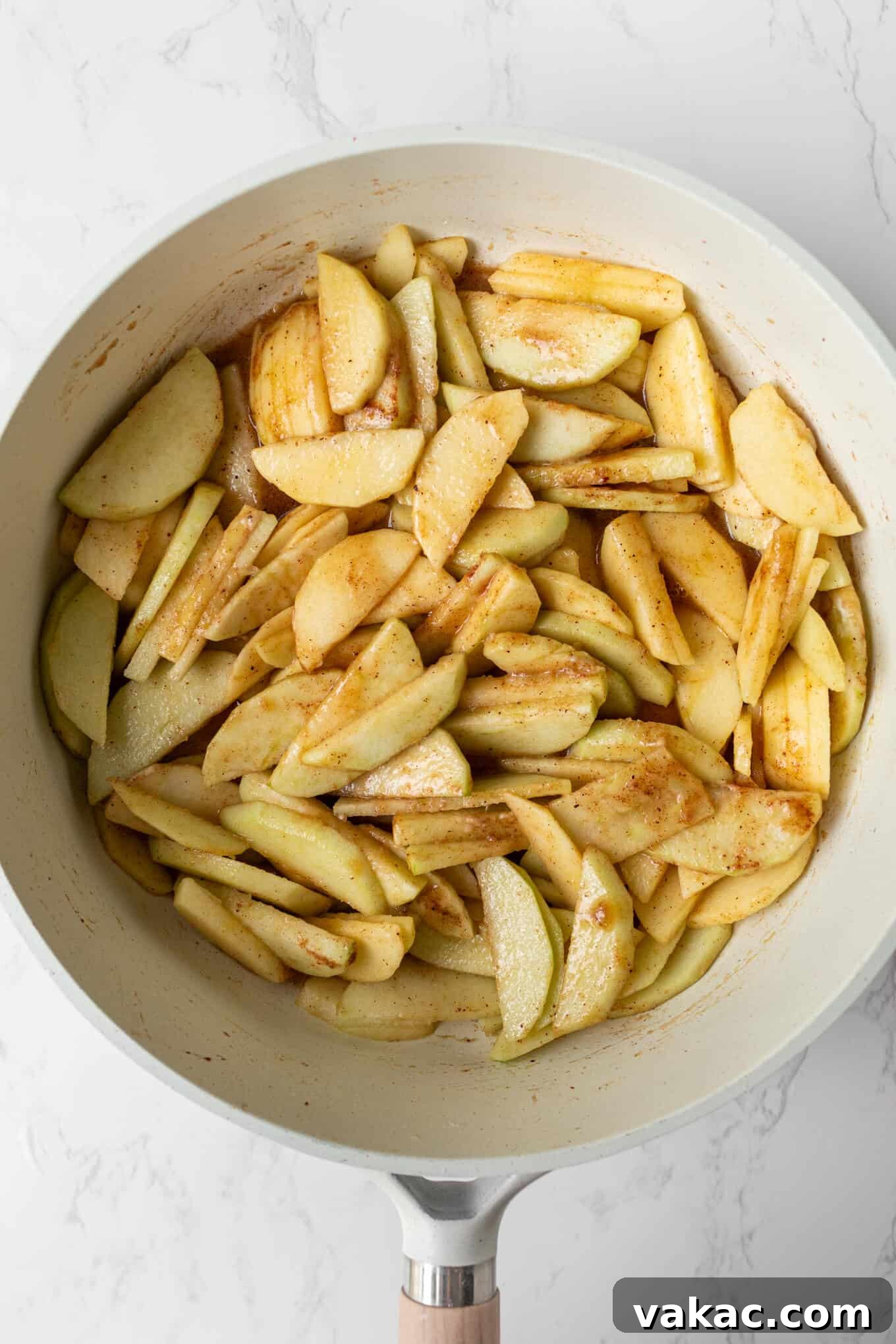 Classic Apple Cobbler with Cinnamon Crumble 5 An overhead view of sliced apples precooking in a saucepan.